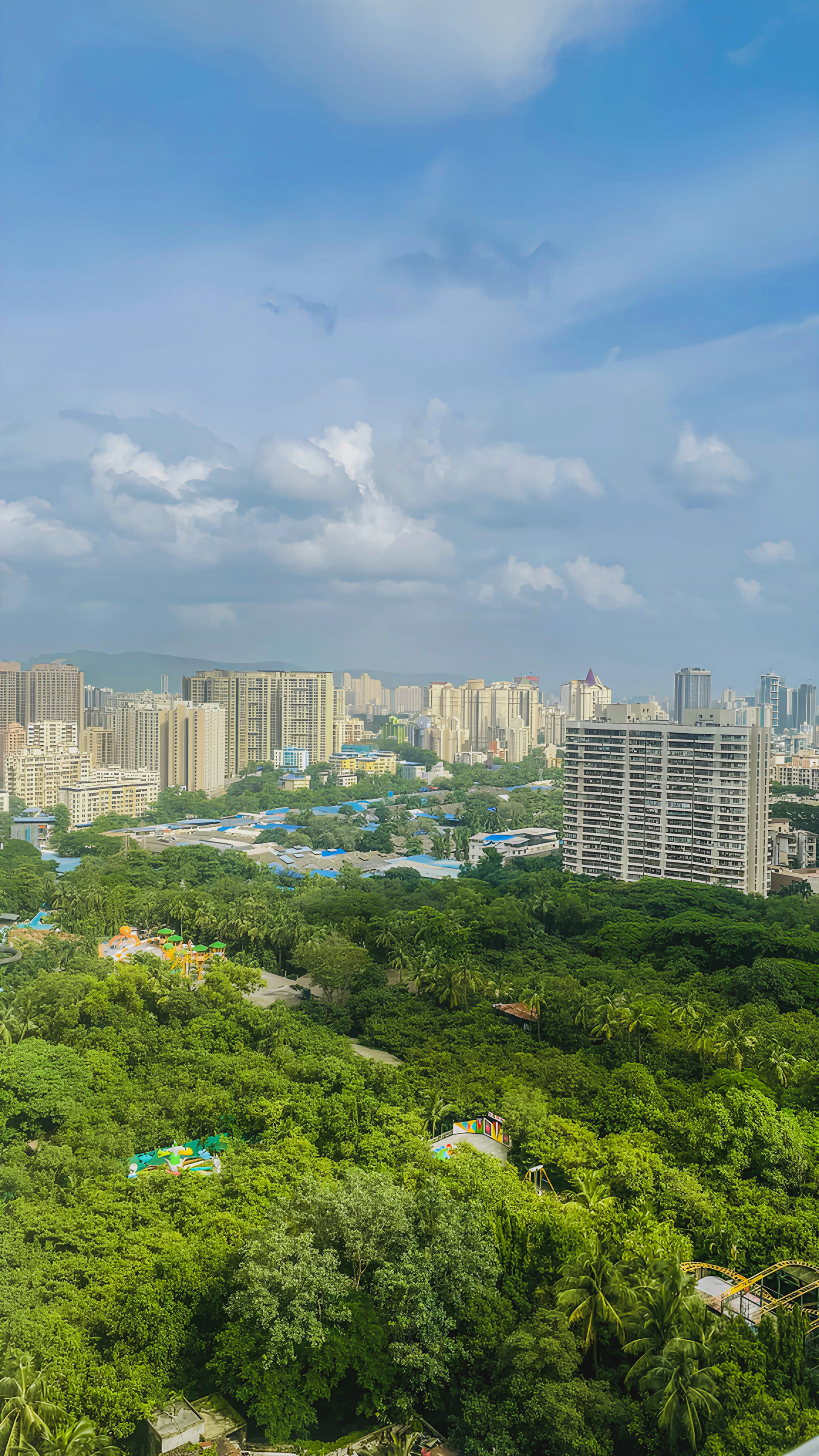 Cityscape with buildings and lush green trees.