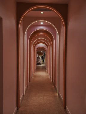A pink hallway with archways and neon lighting