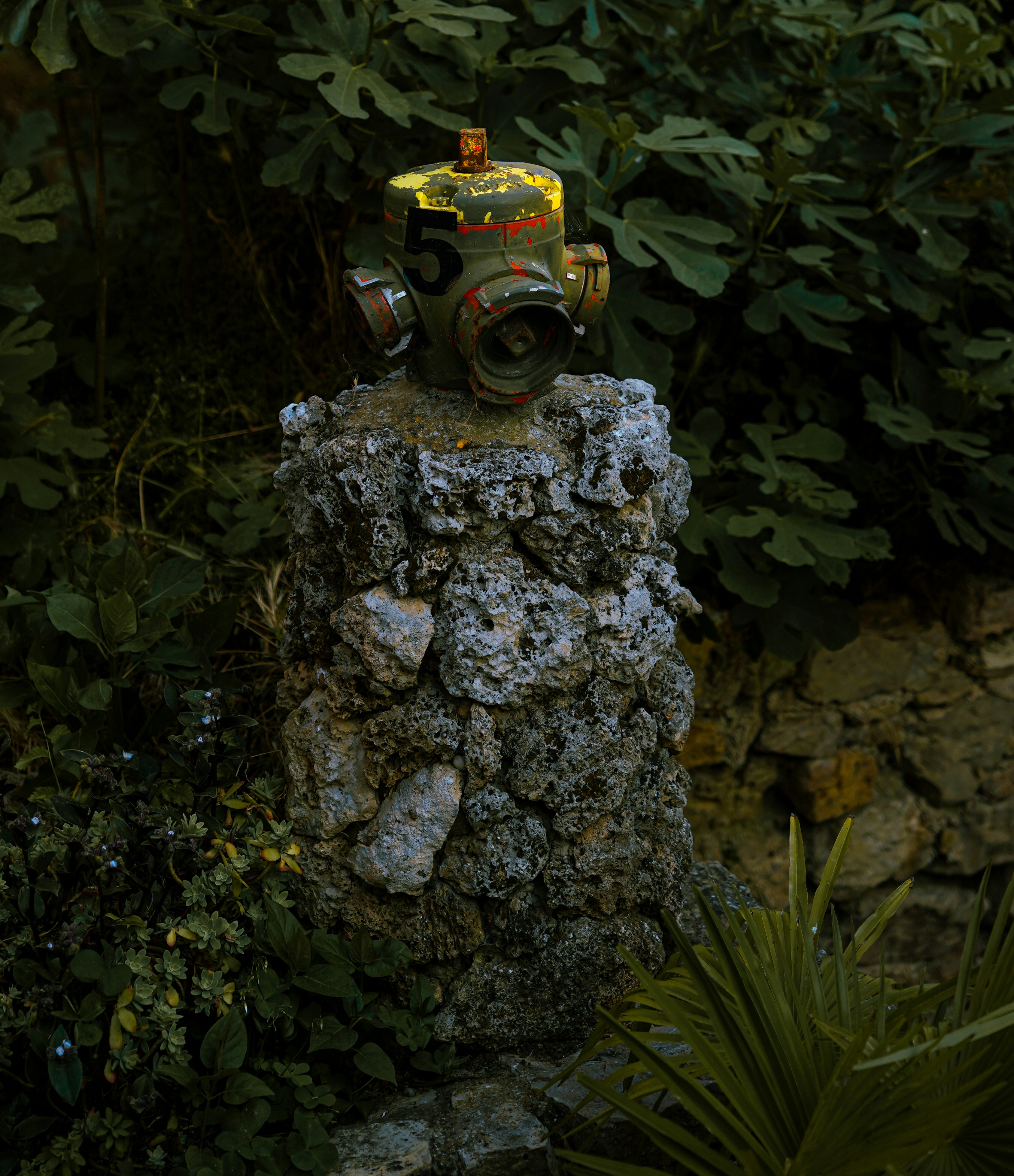 A fire hydrant rests atop a stone pillar.