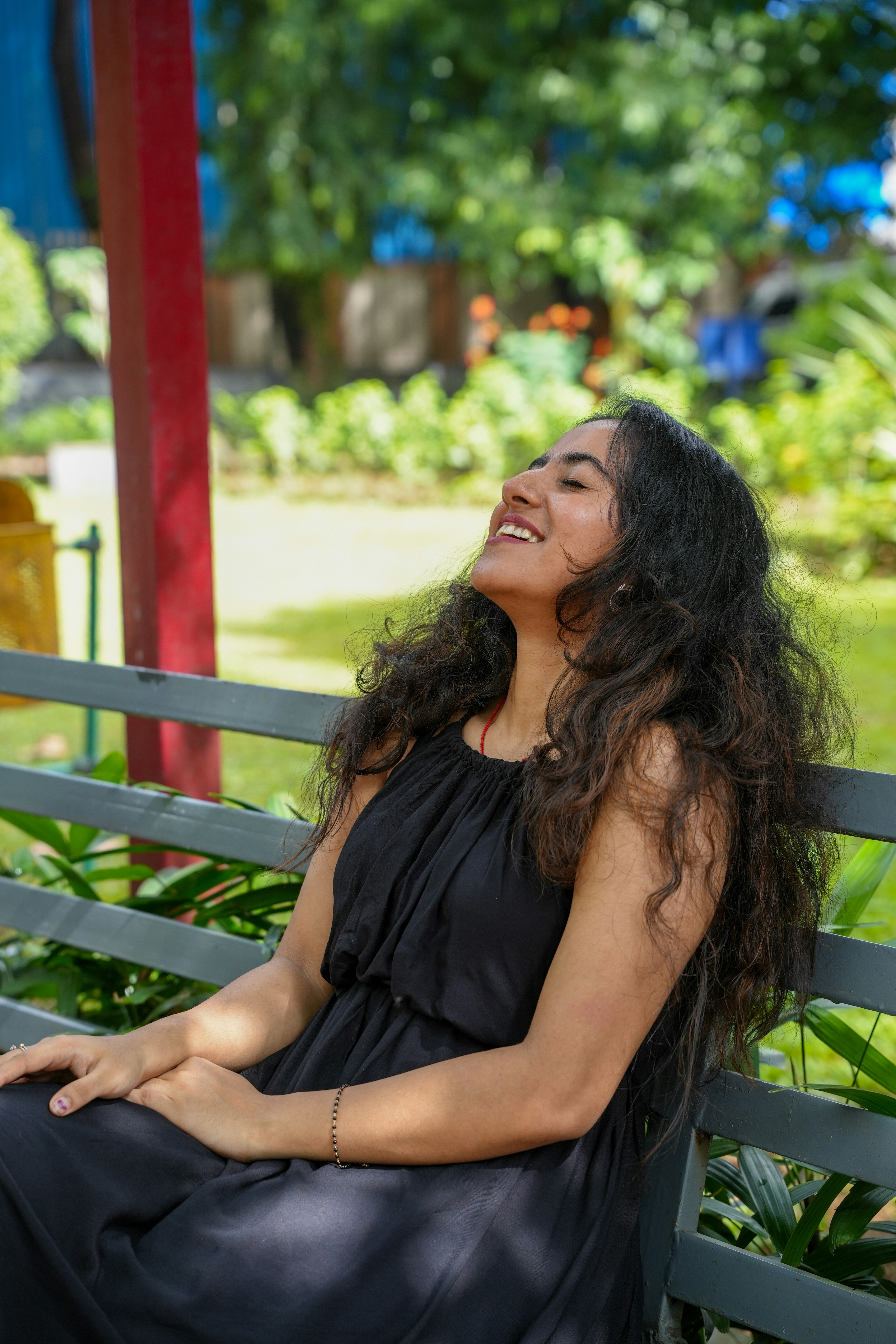 A smiling woman sitting on a park bench