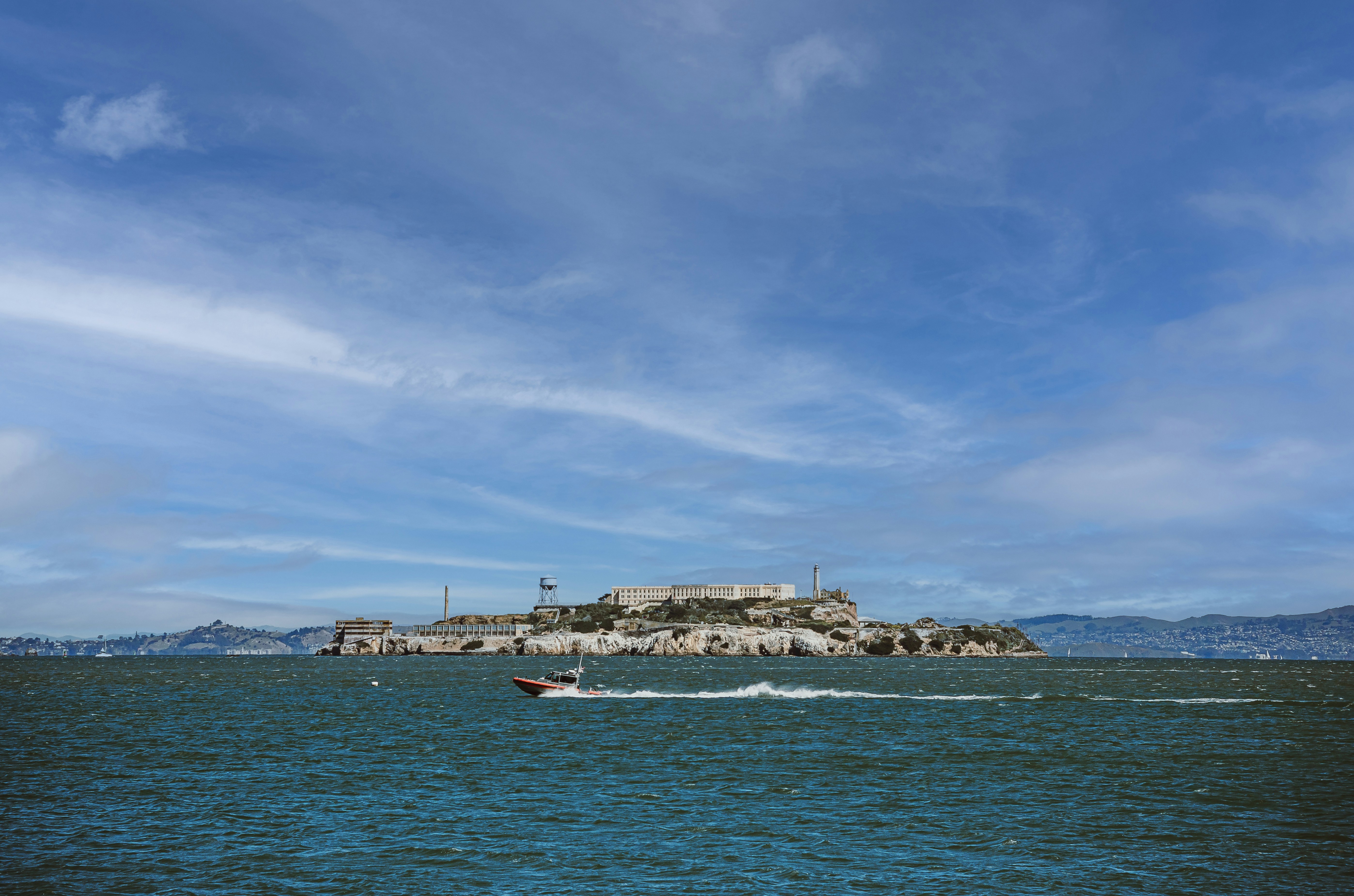 Alcatraz island rises against a cloudy sky.