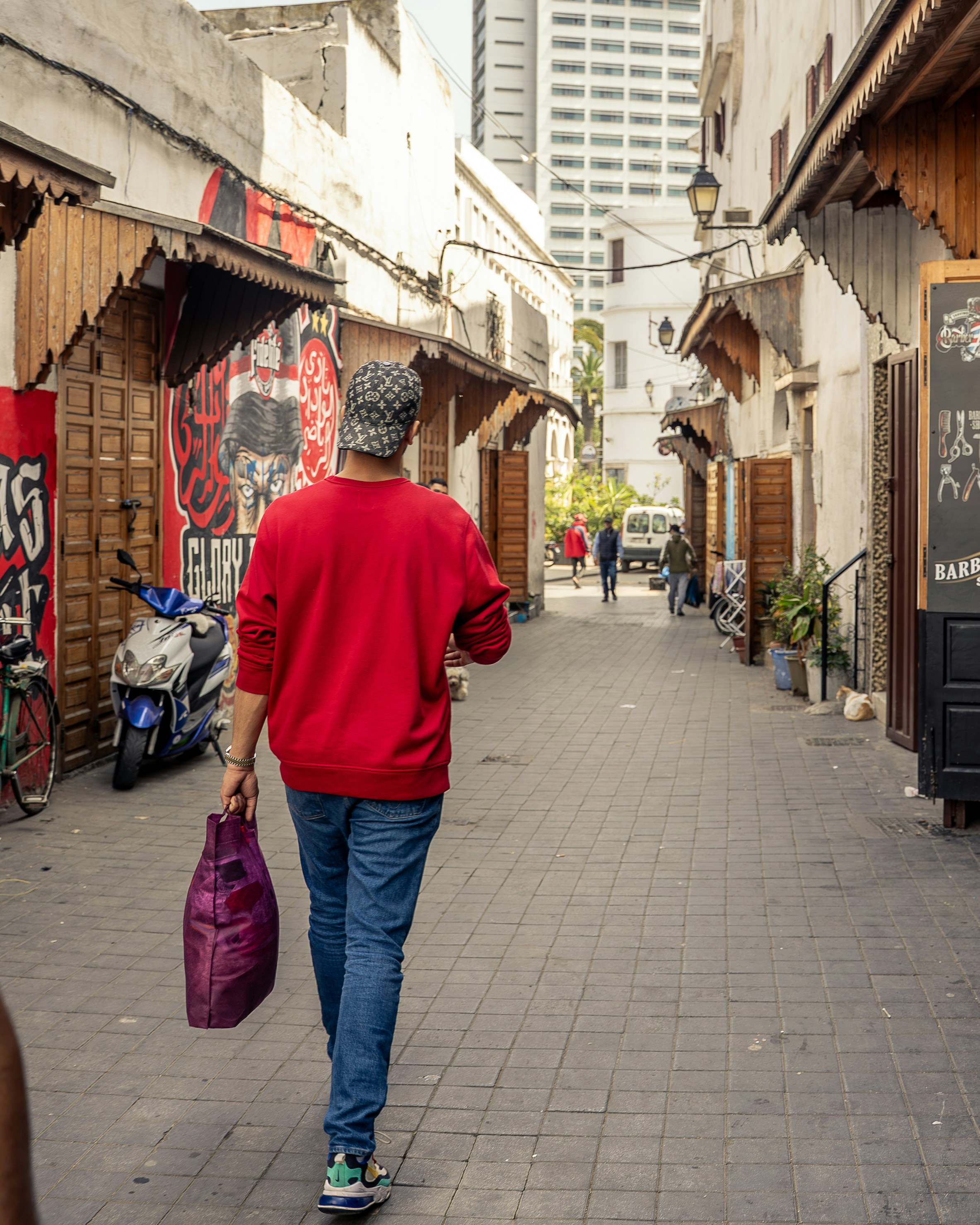 A person walks down a narrow city street.