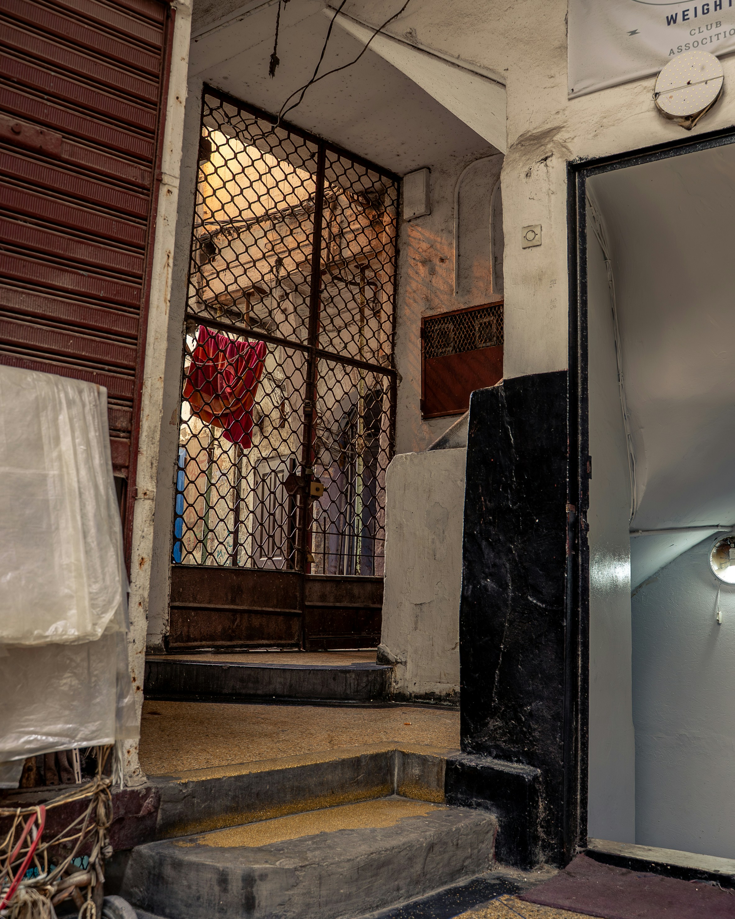 A dark alleyway with a metal gate.