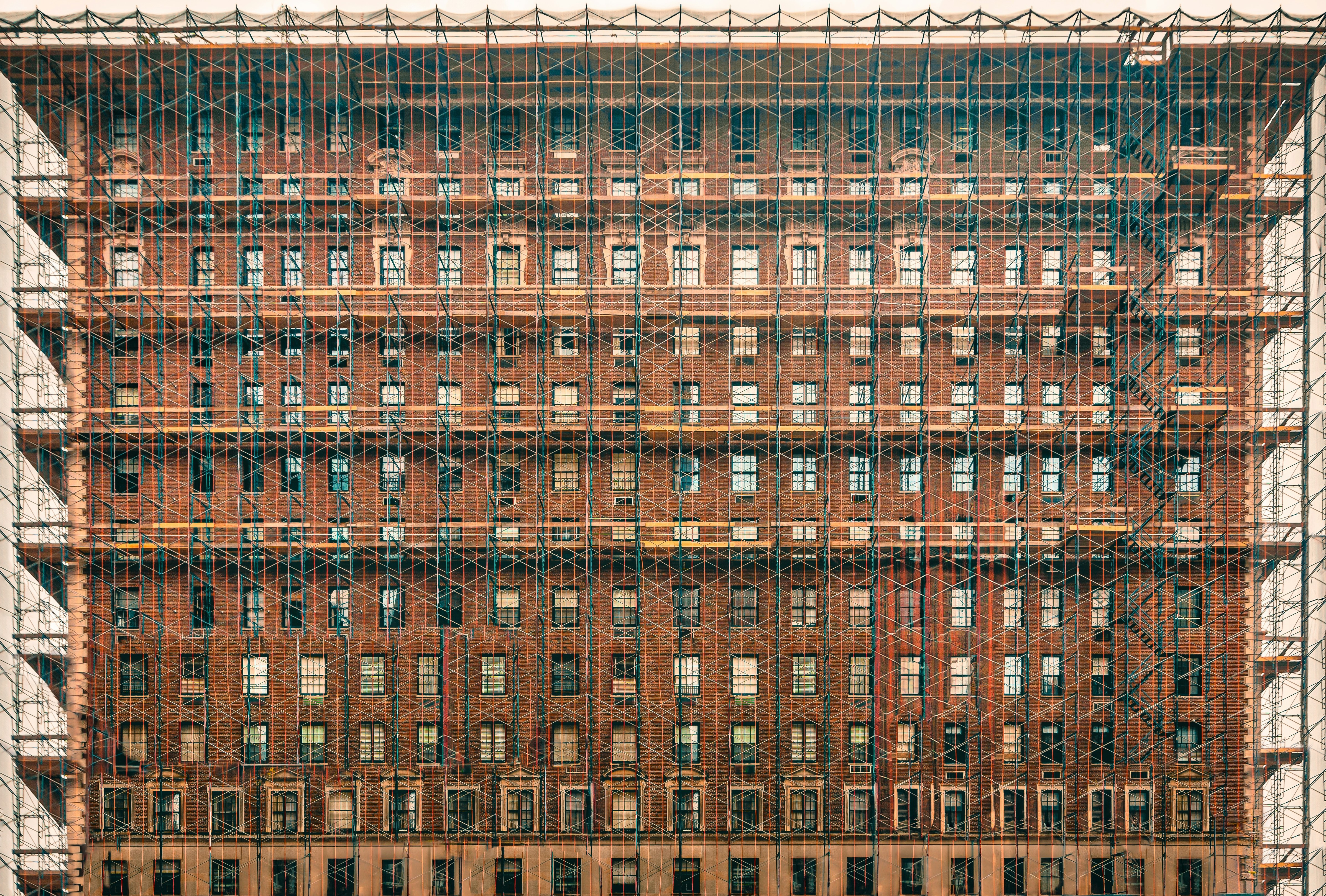 Building facade encased in scaffolding, undergoing construction.
