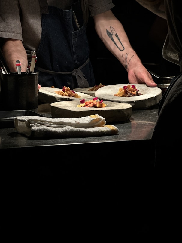 Chef carefully plates food on unique stone plates.