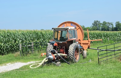 A tractor waters a field of crops.