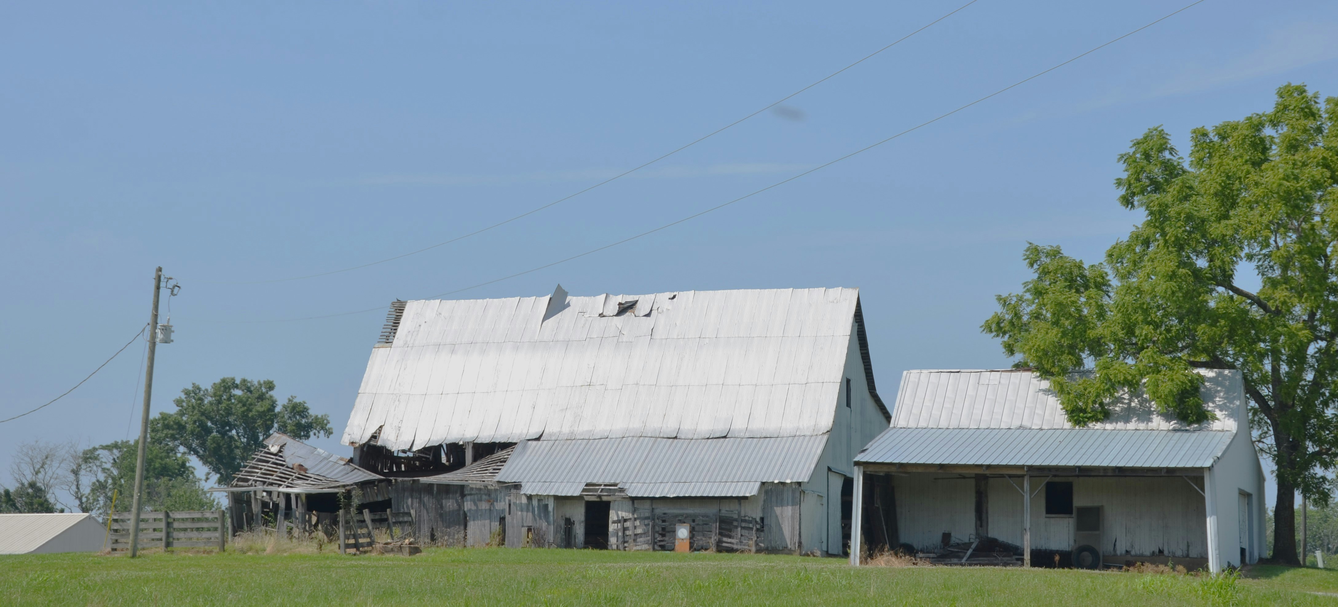 An old barn sits in a grassy field.