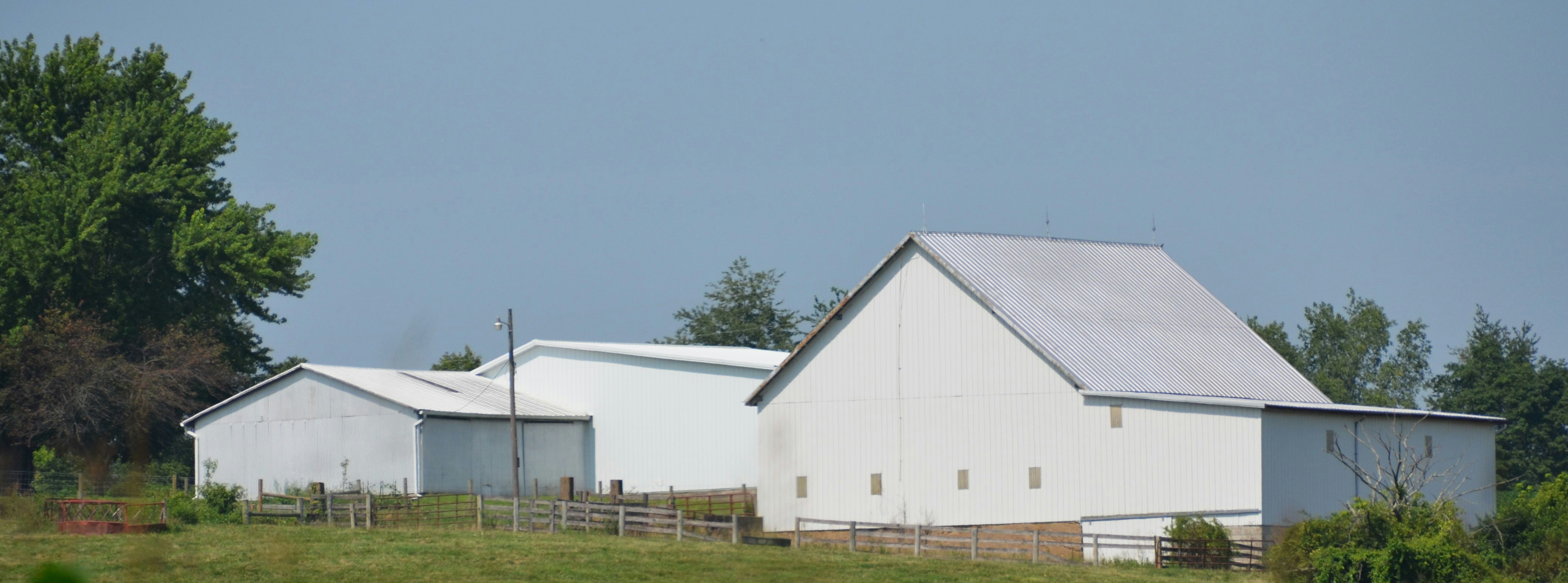 White farm buildings against clear blue sky
