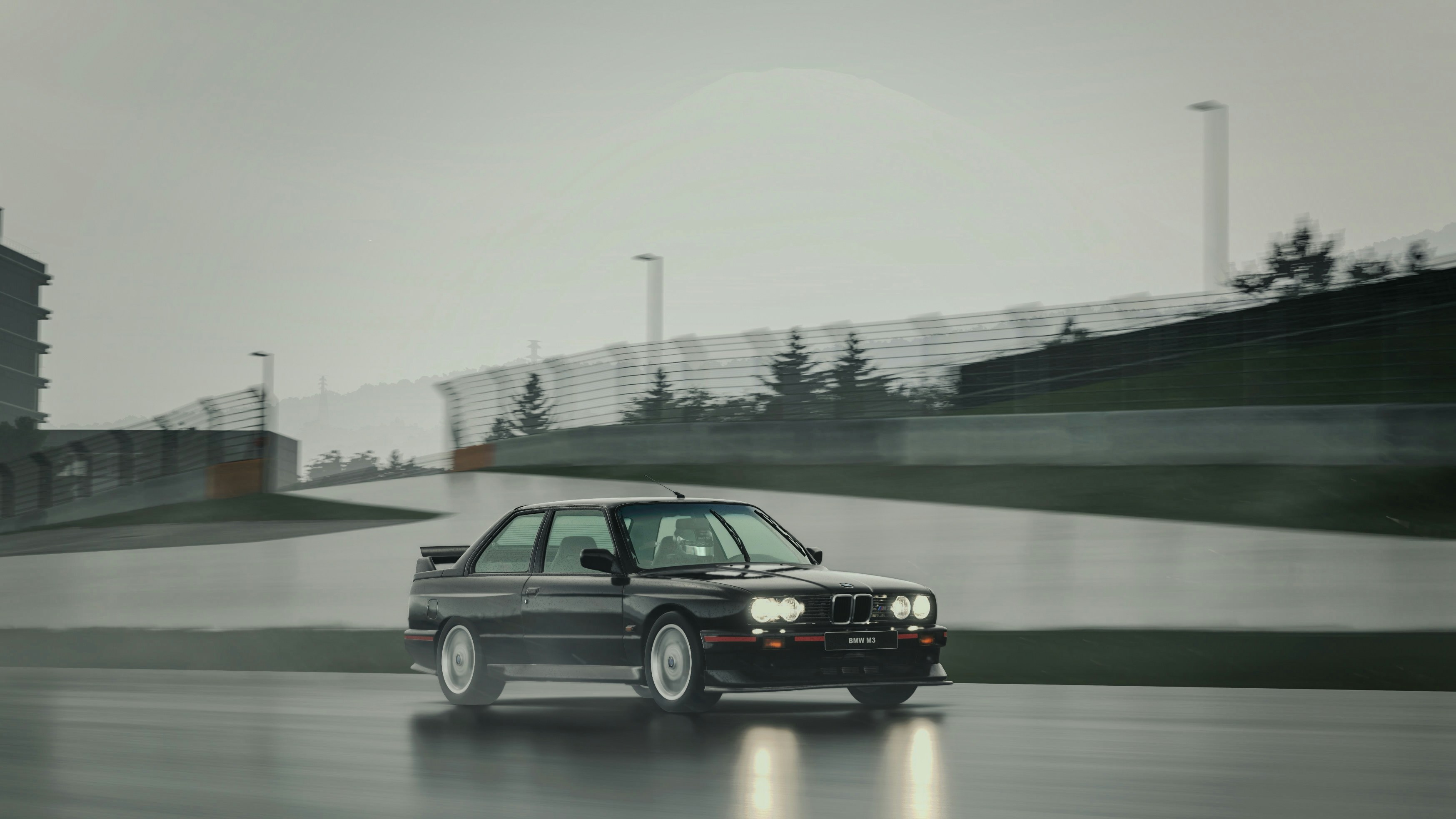 A classic BMW is driving on a wet track.
