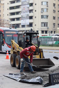 Construction workers are repairing the road with machinery.