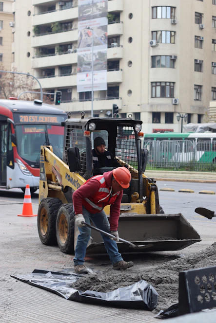 Construction workers are repairing the road with machinery.