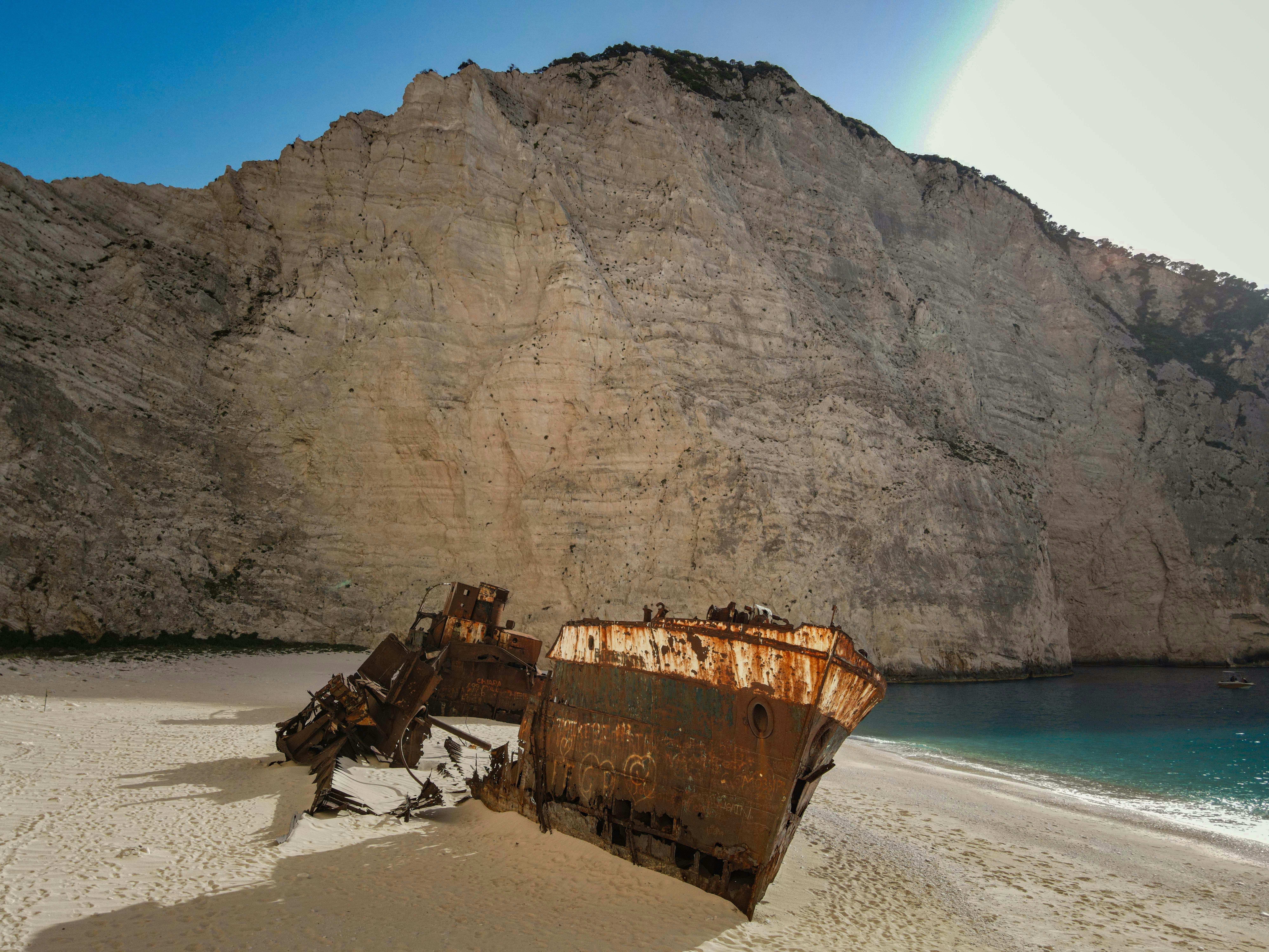 Wrecked ship on a sandy beach by a cliff