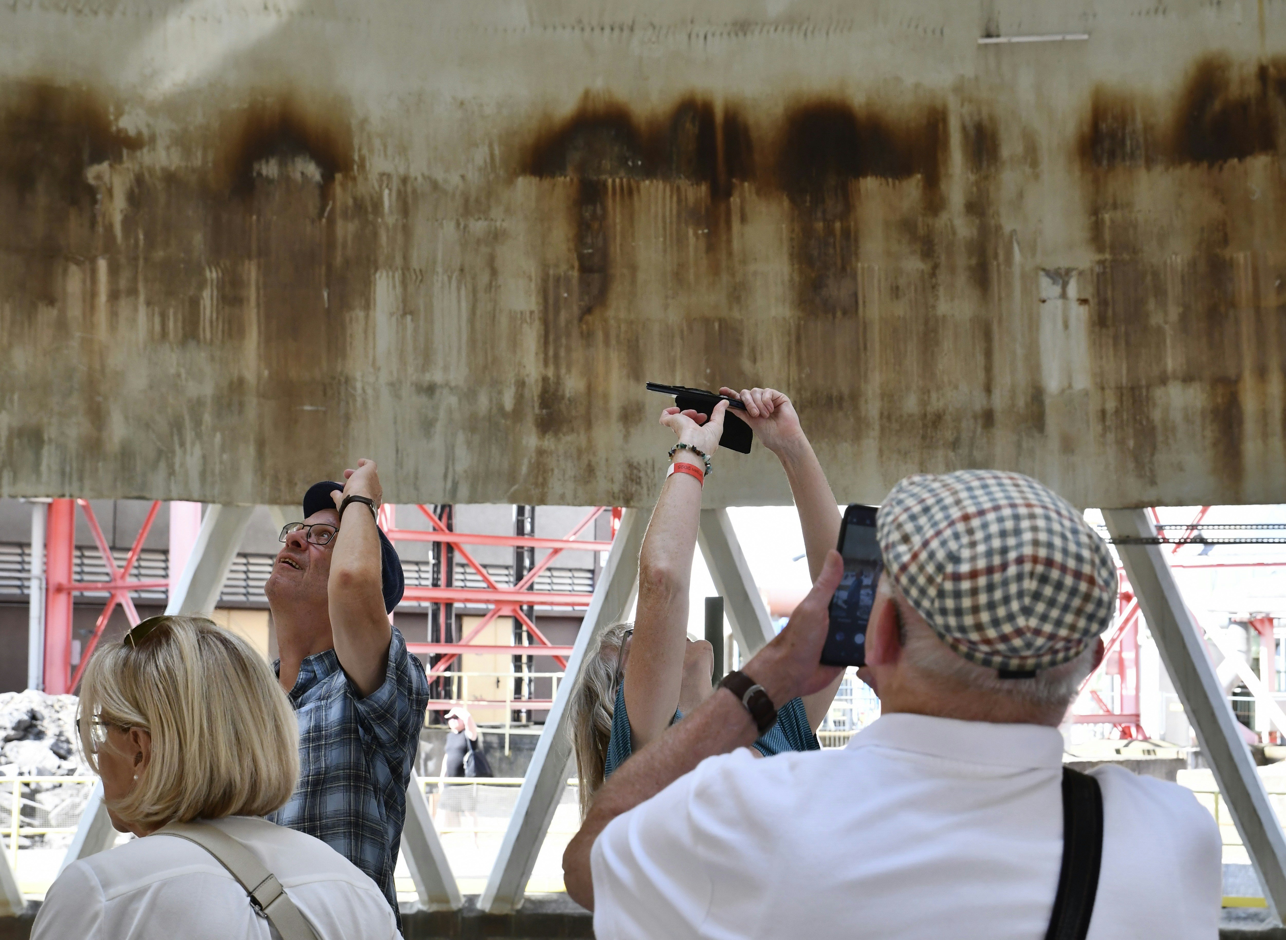 People are looking at a dirty wall.