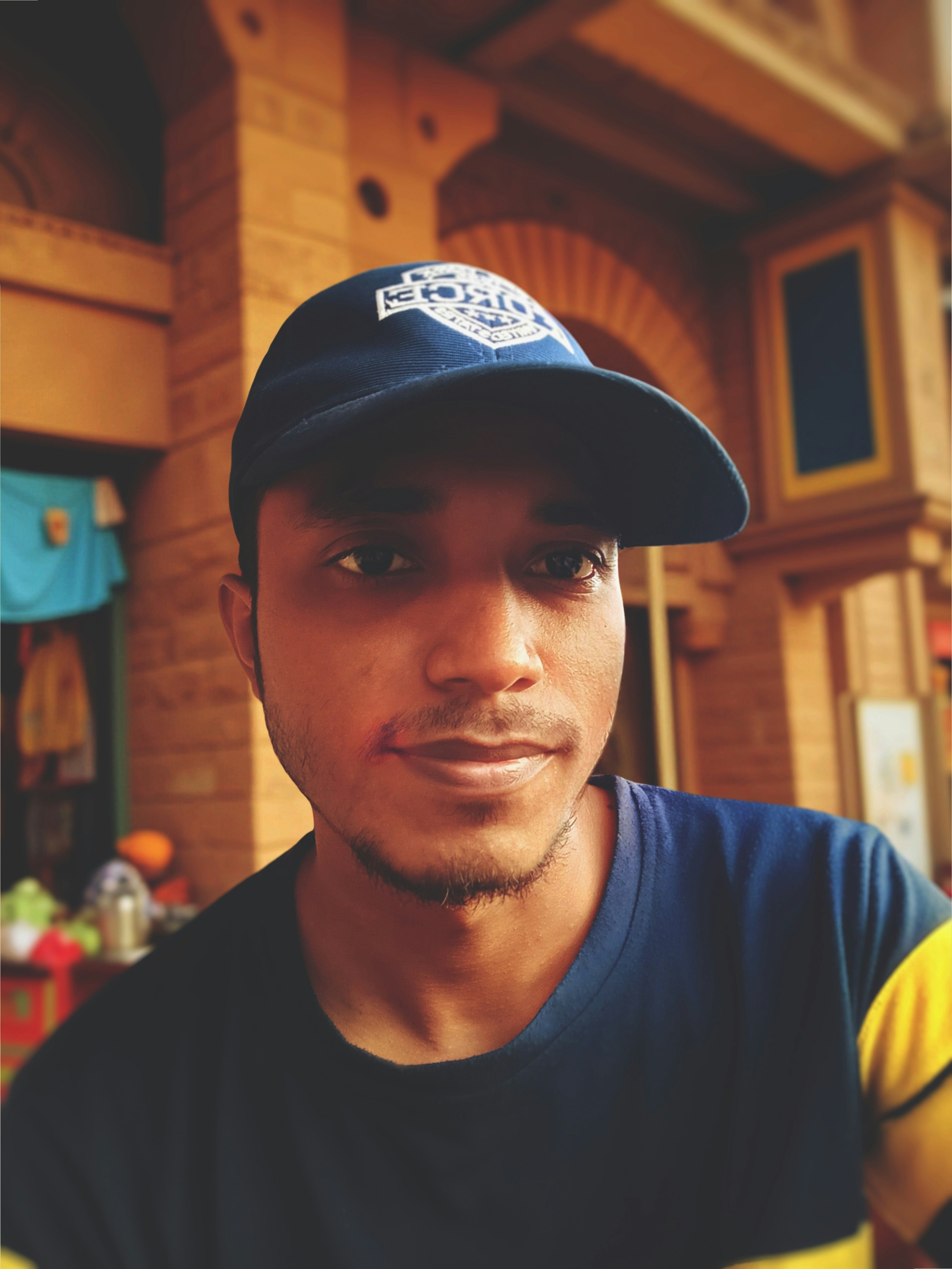 A man in a cap looks directly at the camera.