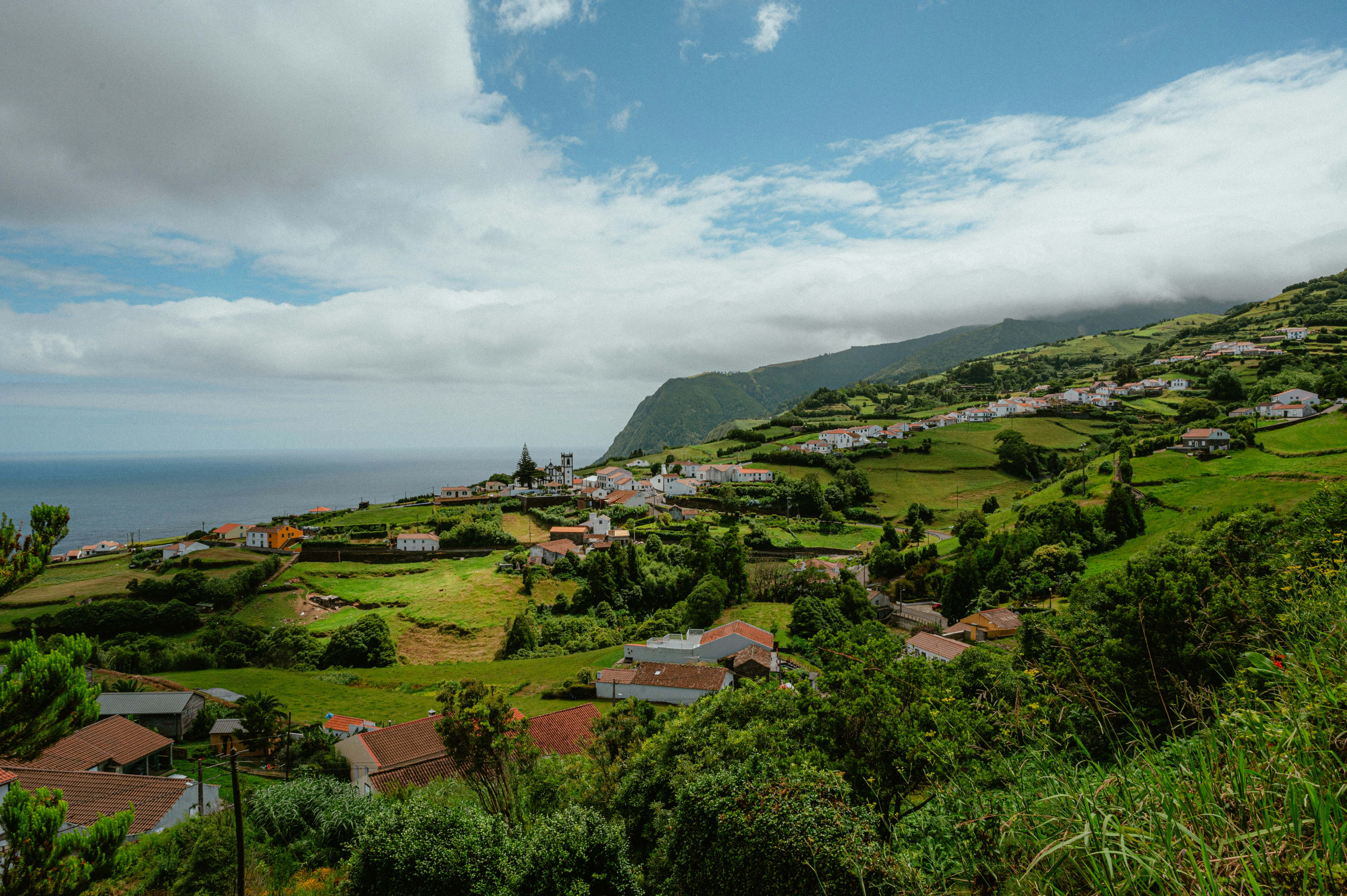 A lush, green village nestled by the sea.