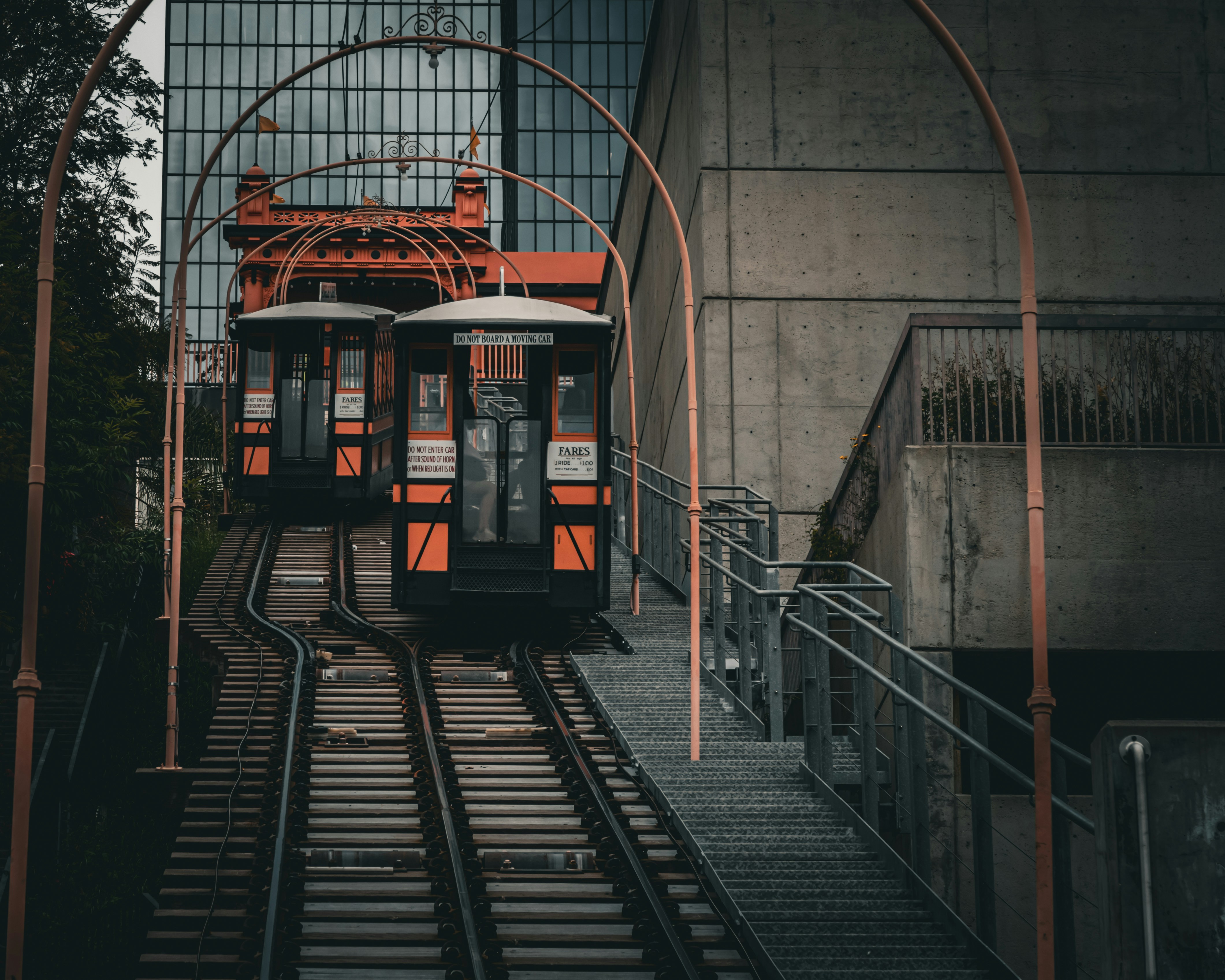 Two cable cars are ascending on tracks., 