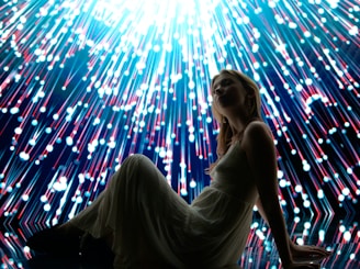 Woman poses with a colorful, bright, light display.