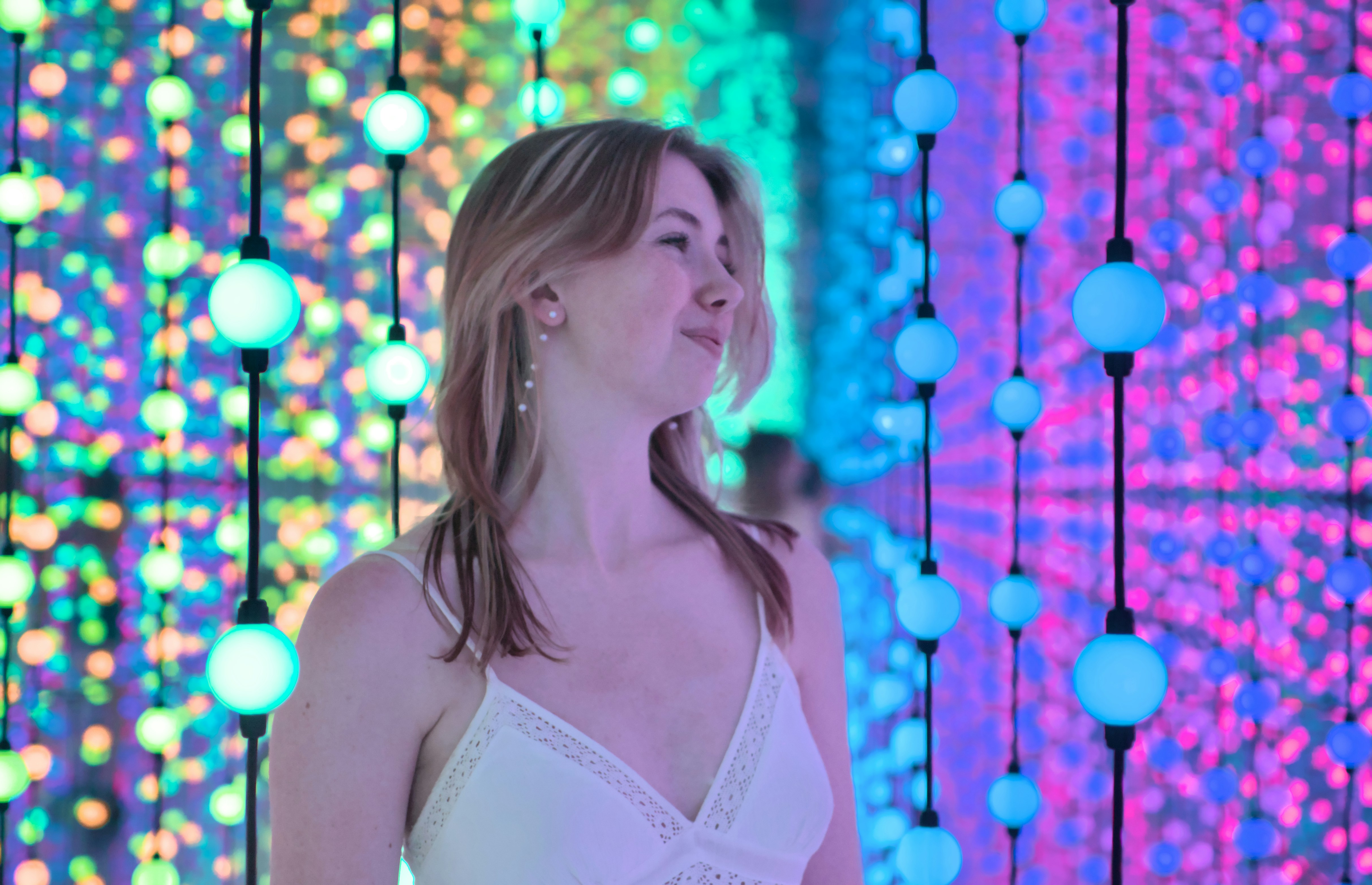 La donna sorride tra luci colorate.