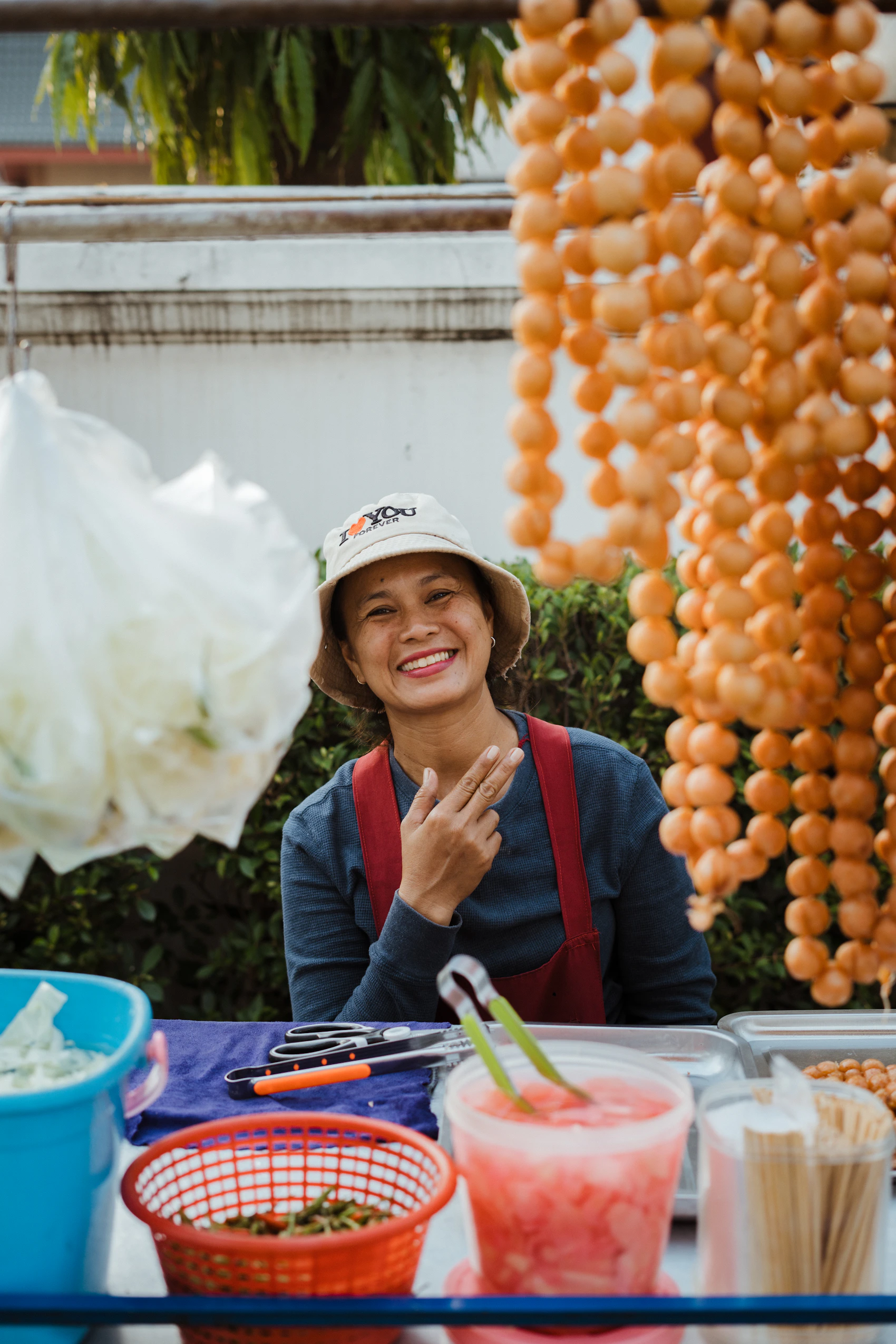 A smiling street-food vendor preparing dishes at her Bangkok stall