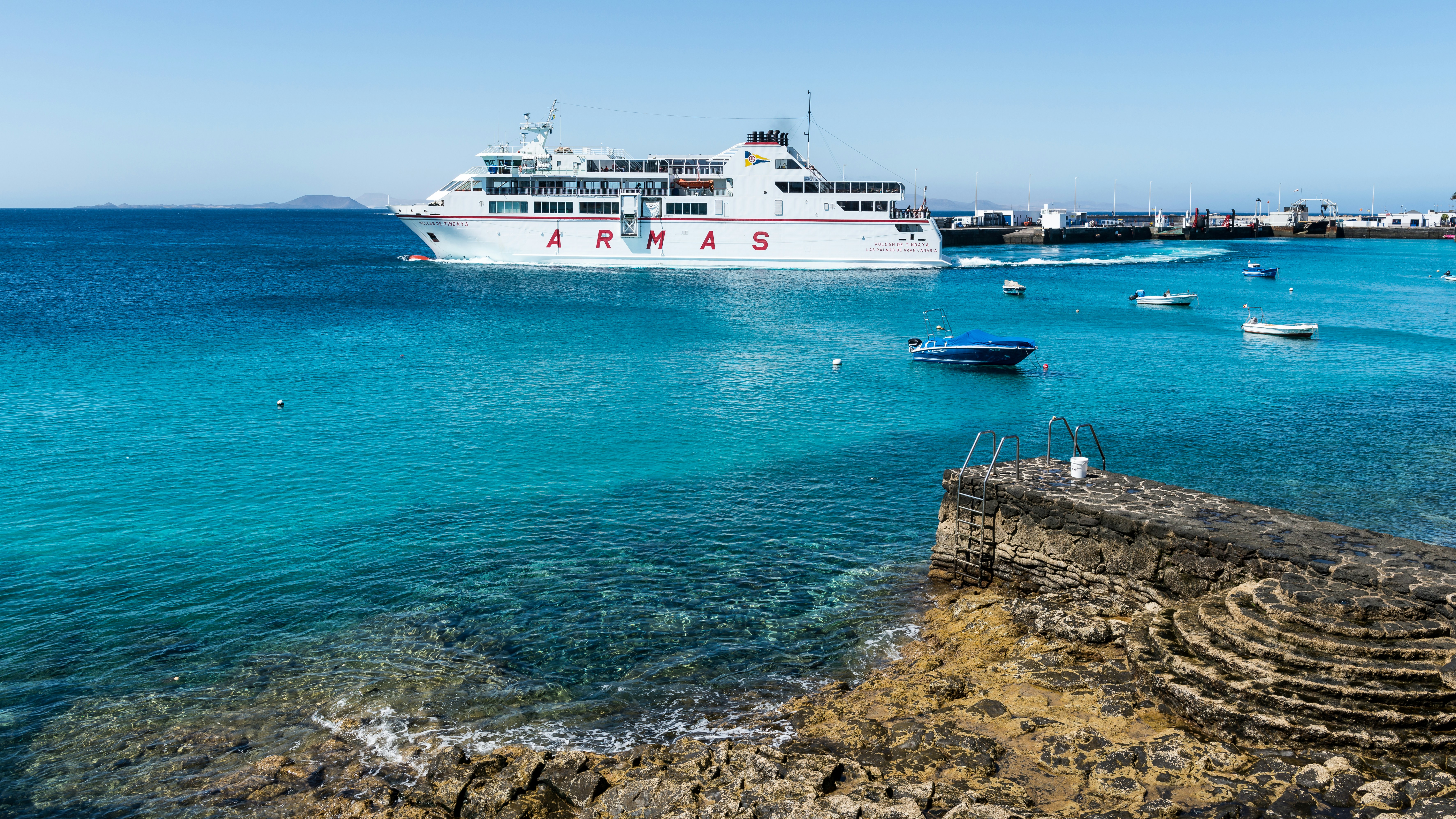 A ferry sits docked in a turquoise ocean.