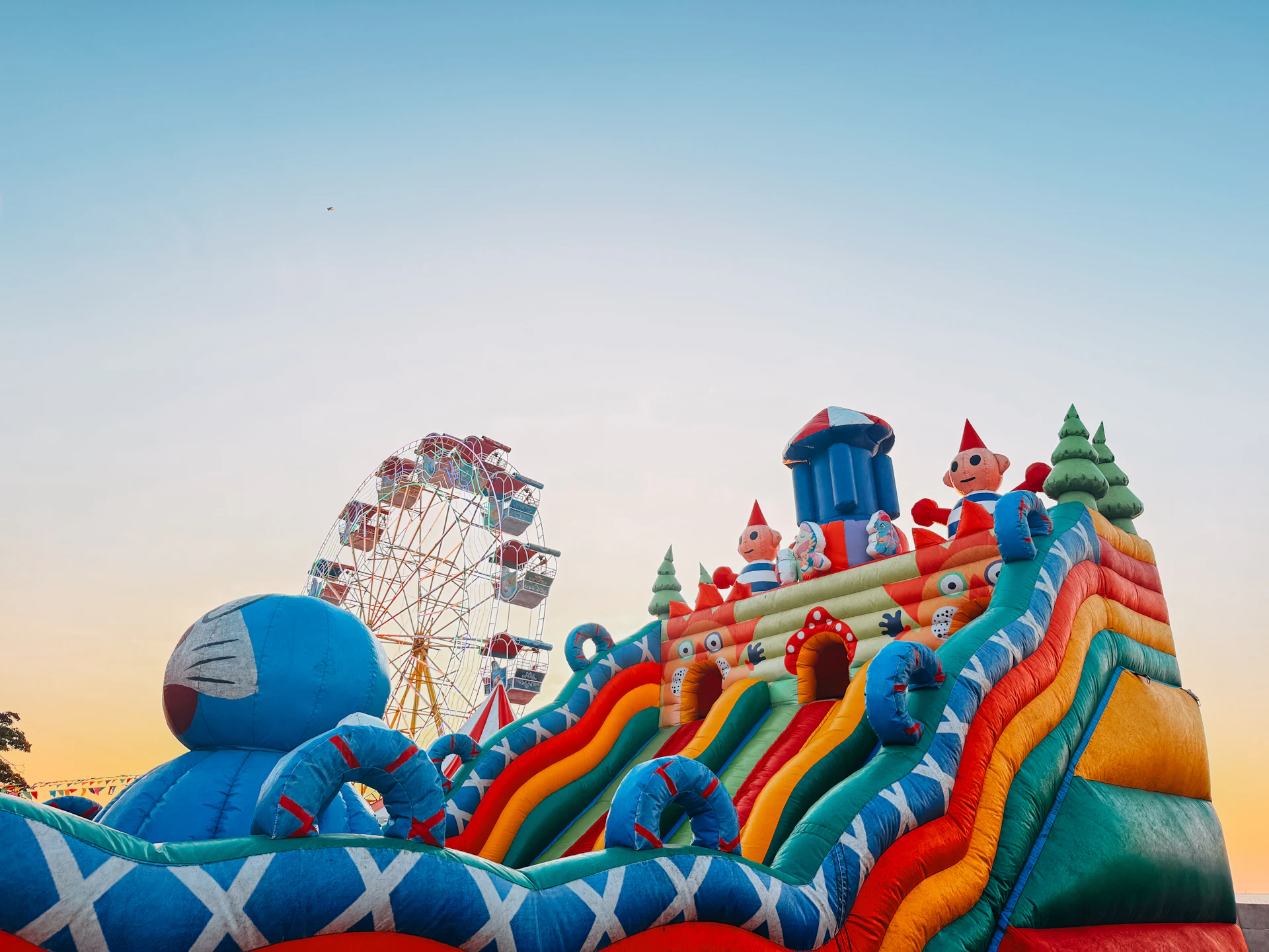 An amusement park with bouncy castles and a ferris wheel.