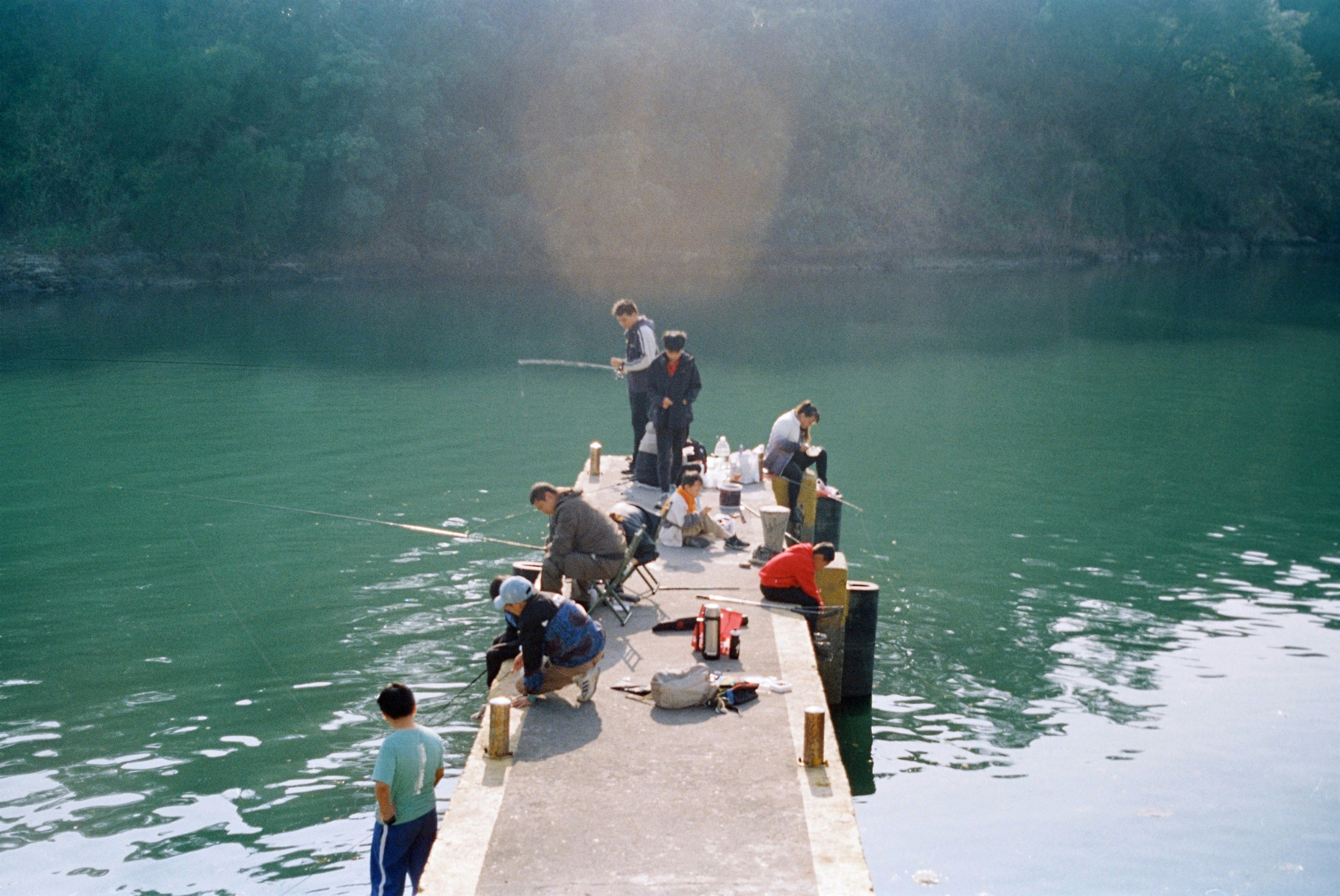 People are fishing off a concrete dock.