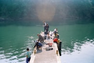 People are fishing off a concrete dock.
