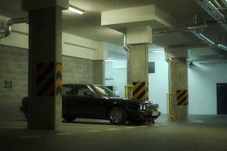 A dark car parked inside a parking garage.