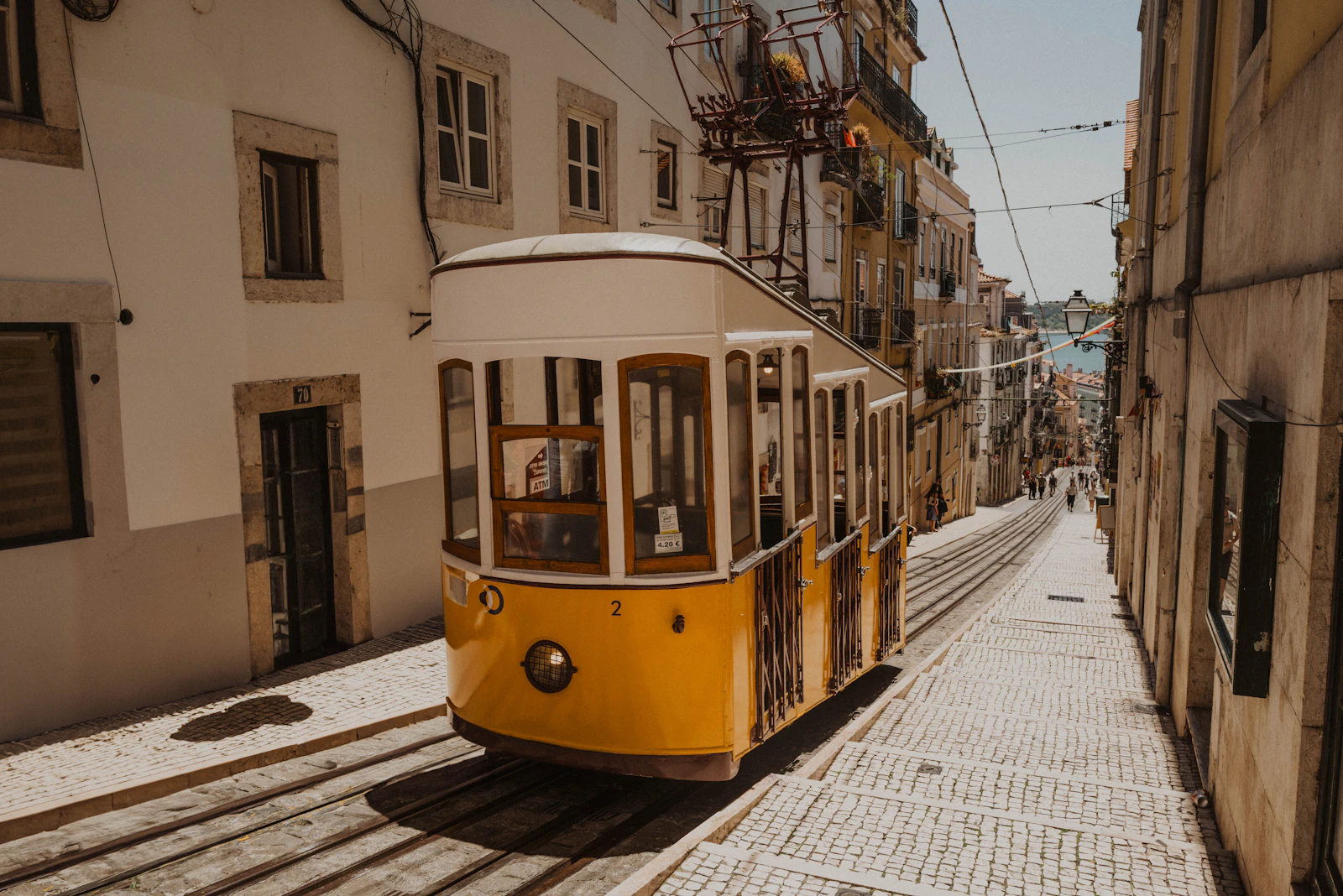 Tramway jaune emblématique dans une rue pavée de Lisbonne