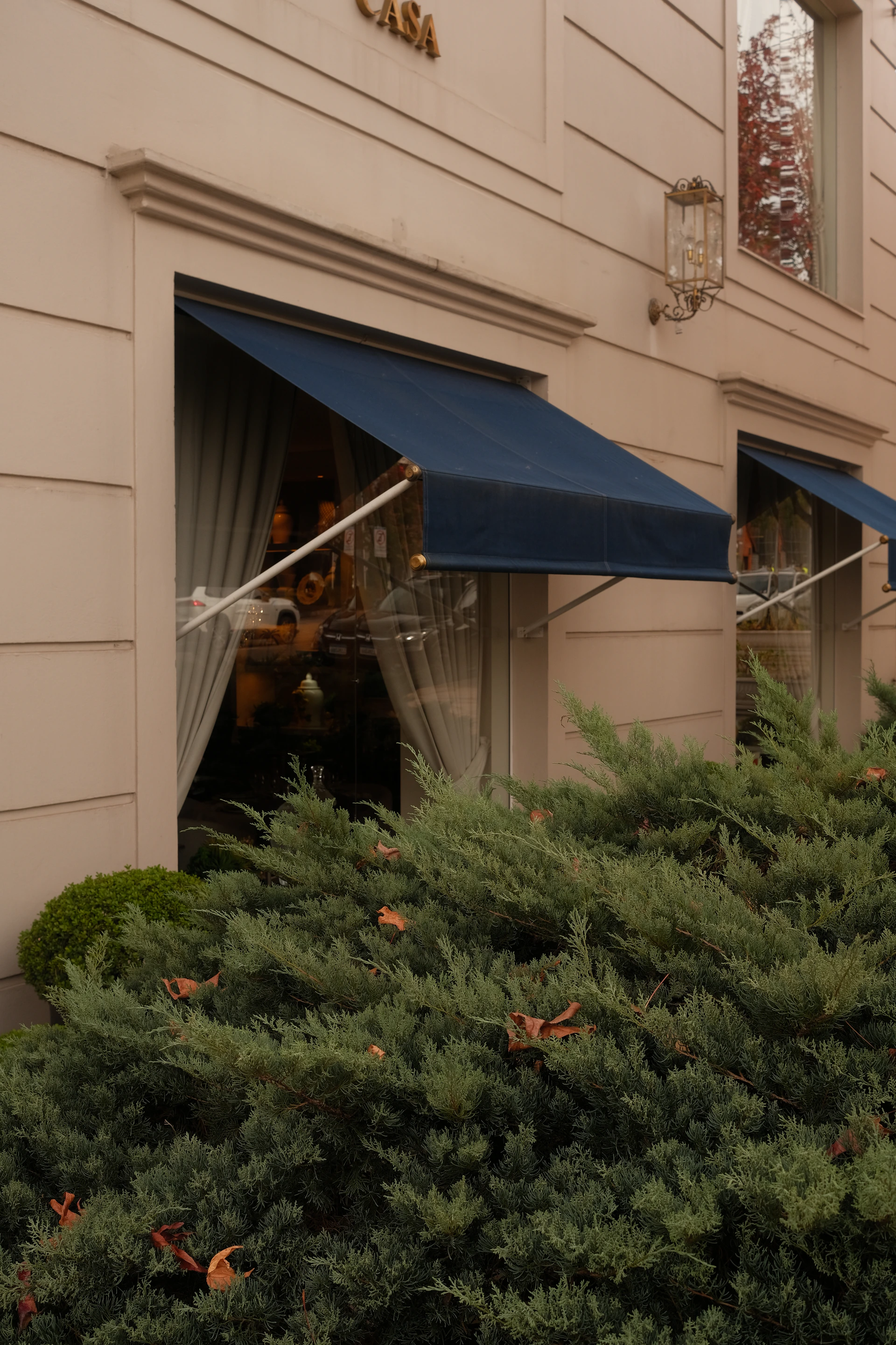 A building with awnings and greenery.