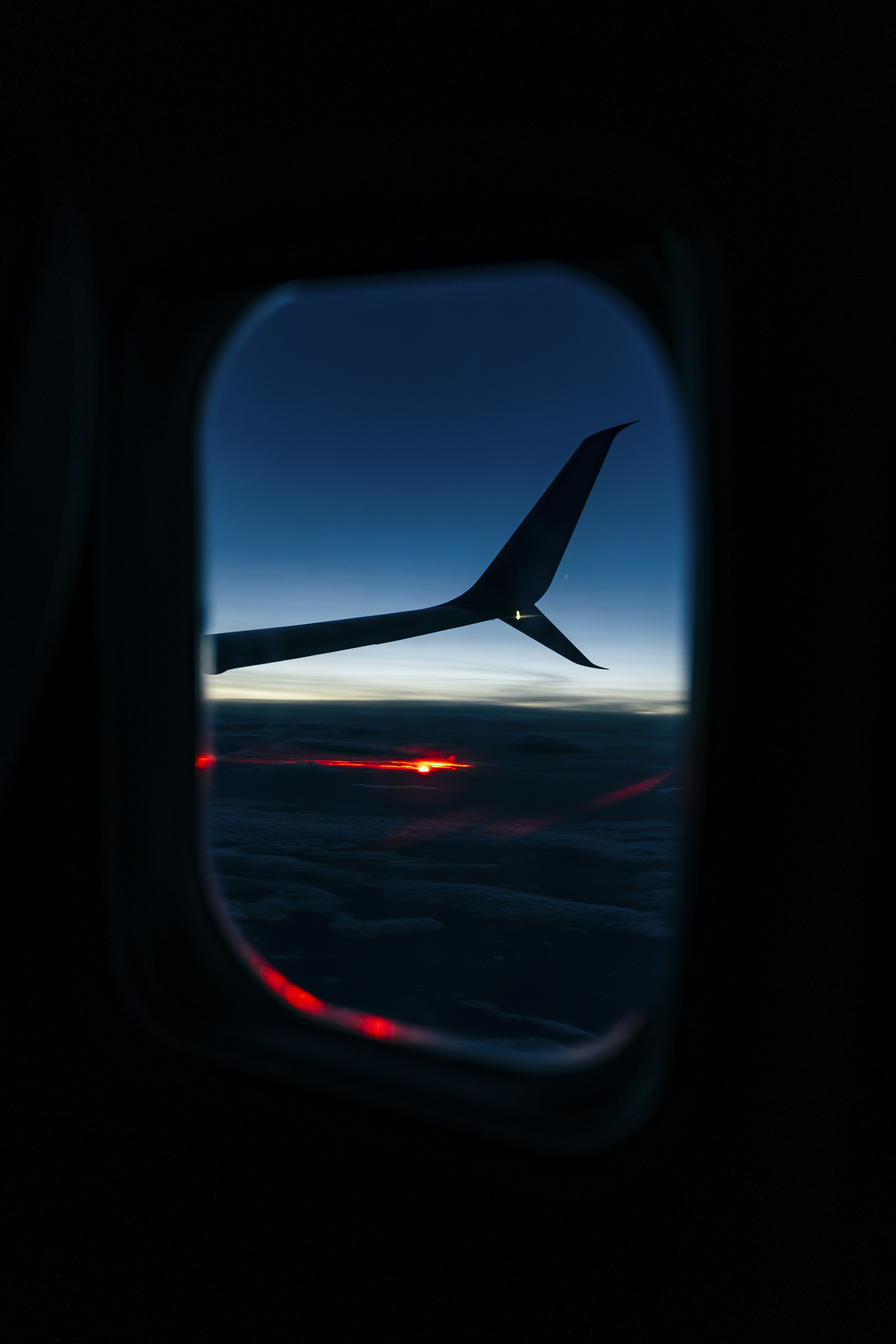 Airplane wing view of a sunrise.