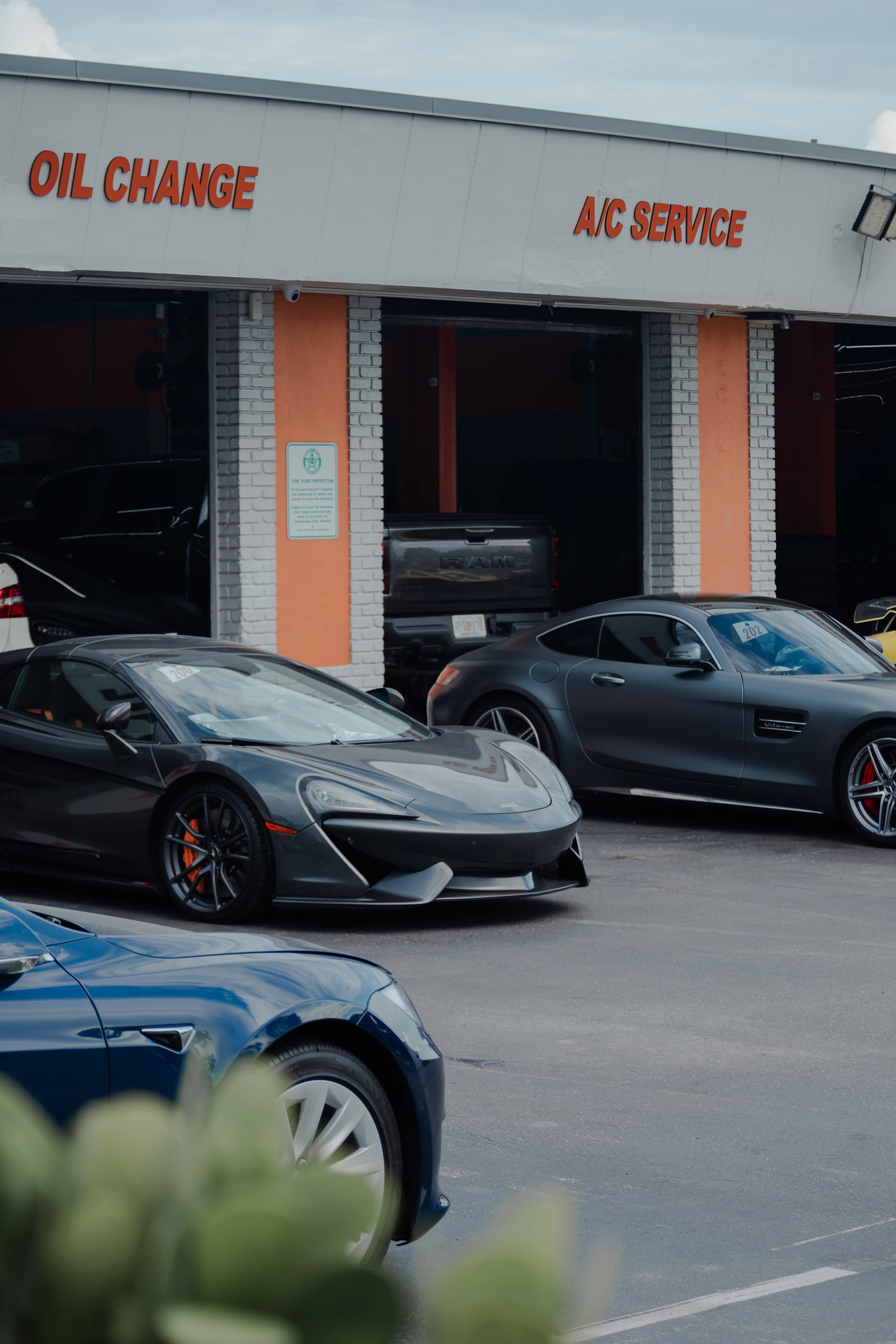 Luxury cars parked in front of a garage.