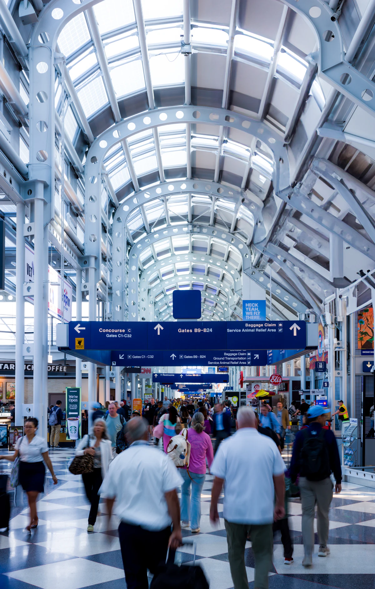 Travelers walk through a busy airport terminal