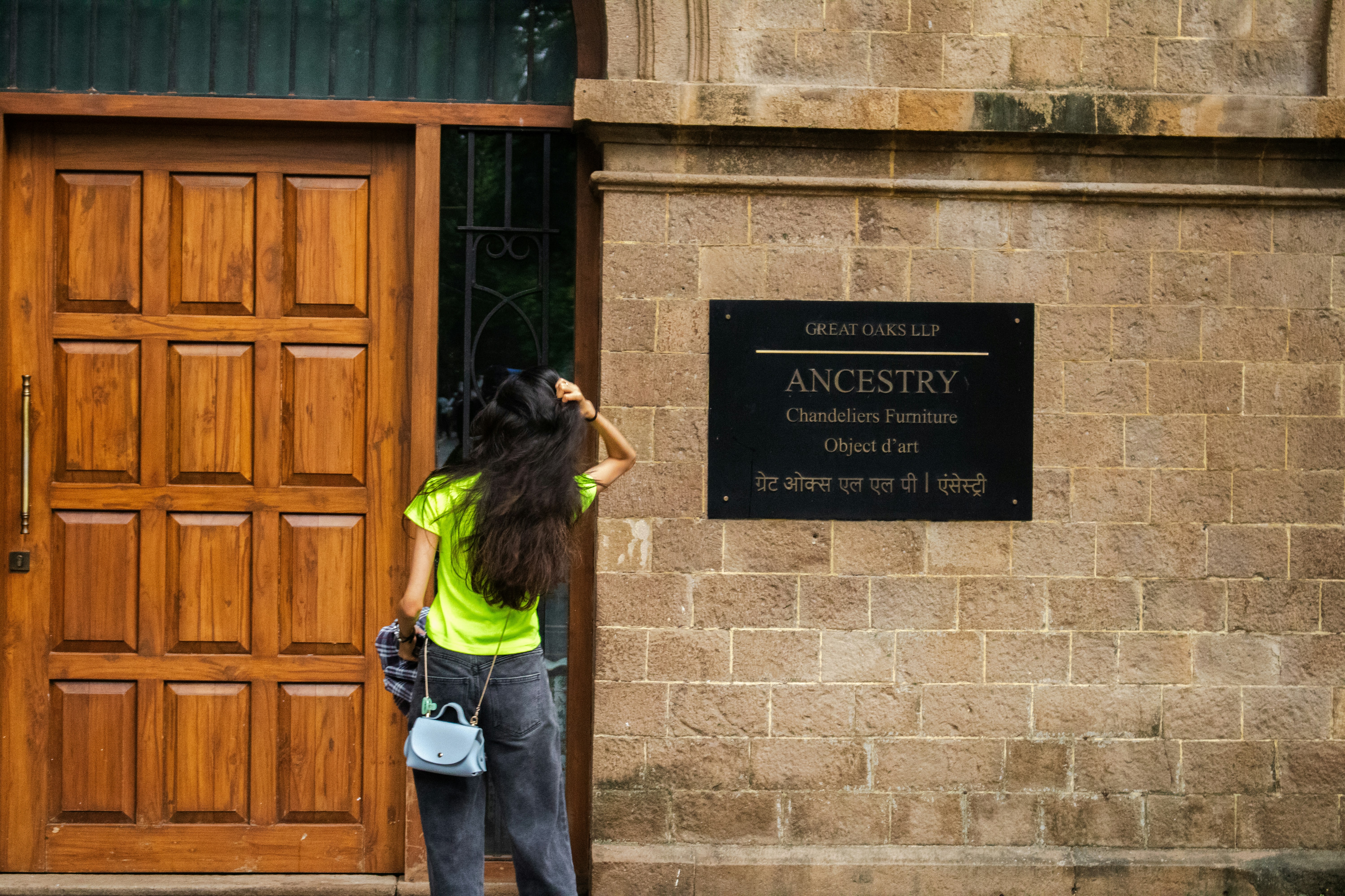 Woman looks at a sign outside a building.
