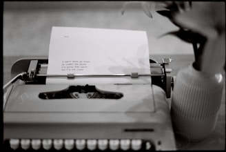 Typewriter with a typed poem next to a vase.