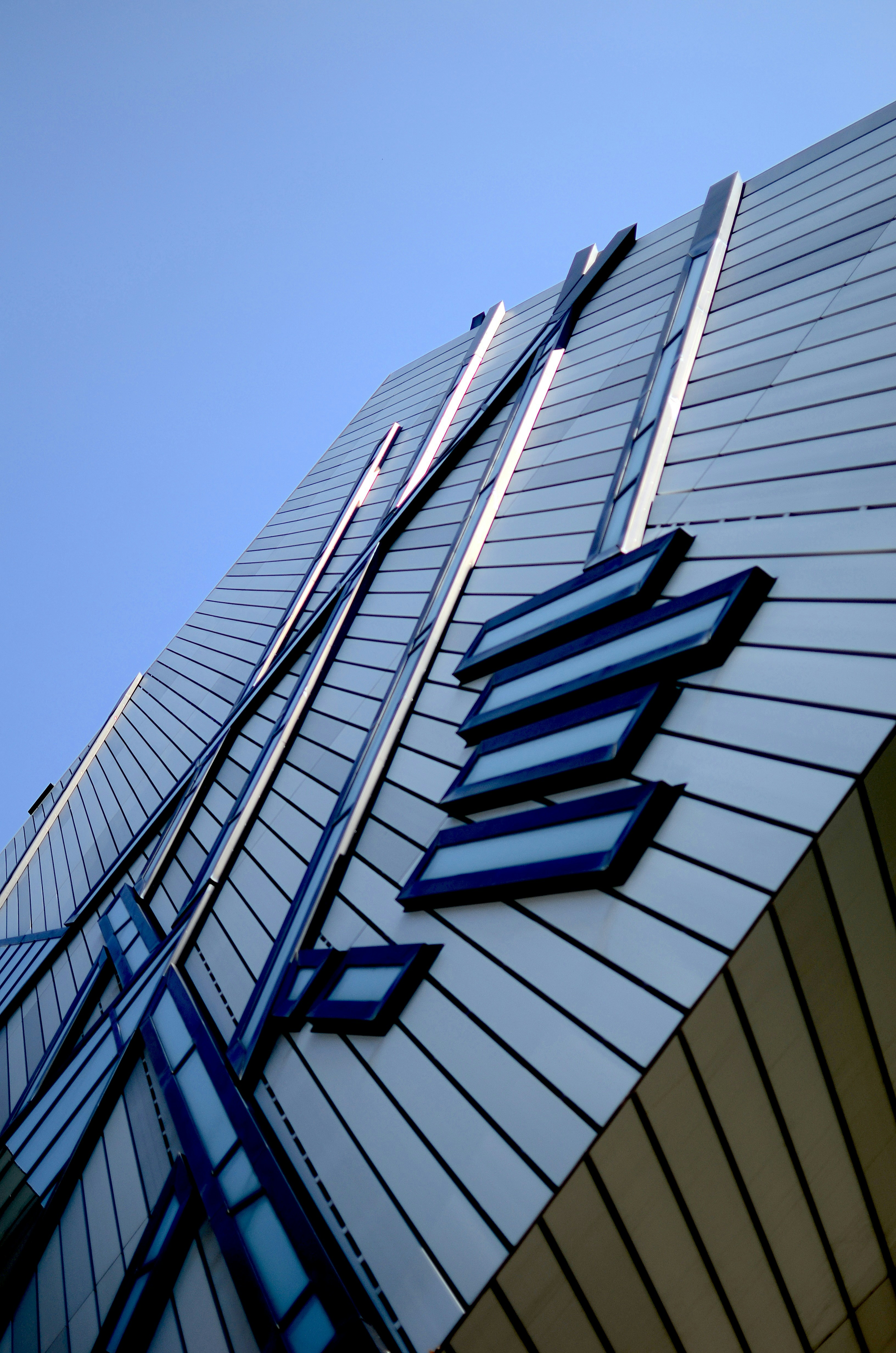 Bâtiment moderne avec des accents bleus sur un ciel bleu.