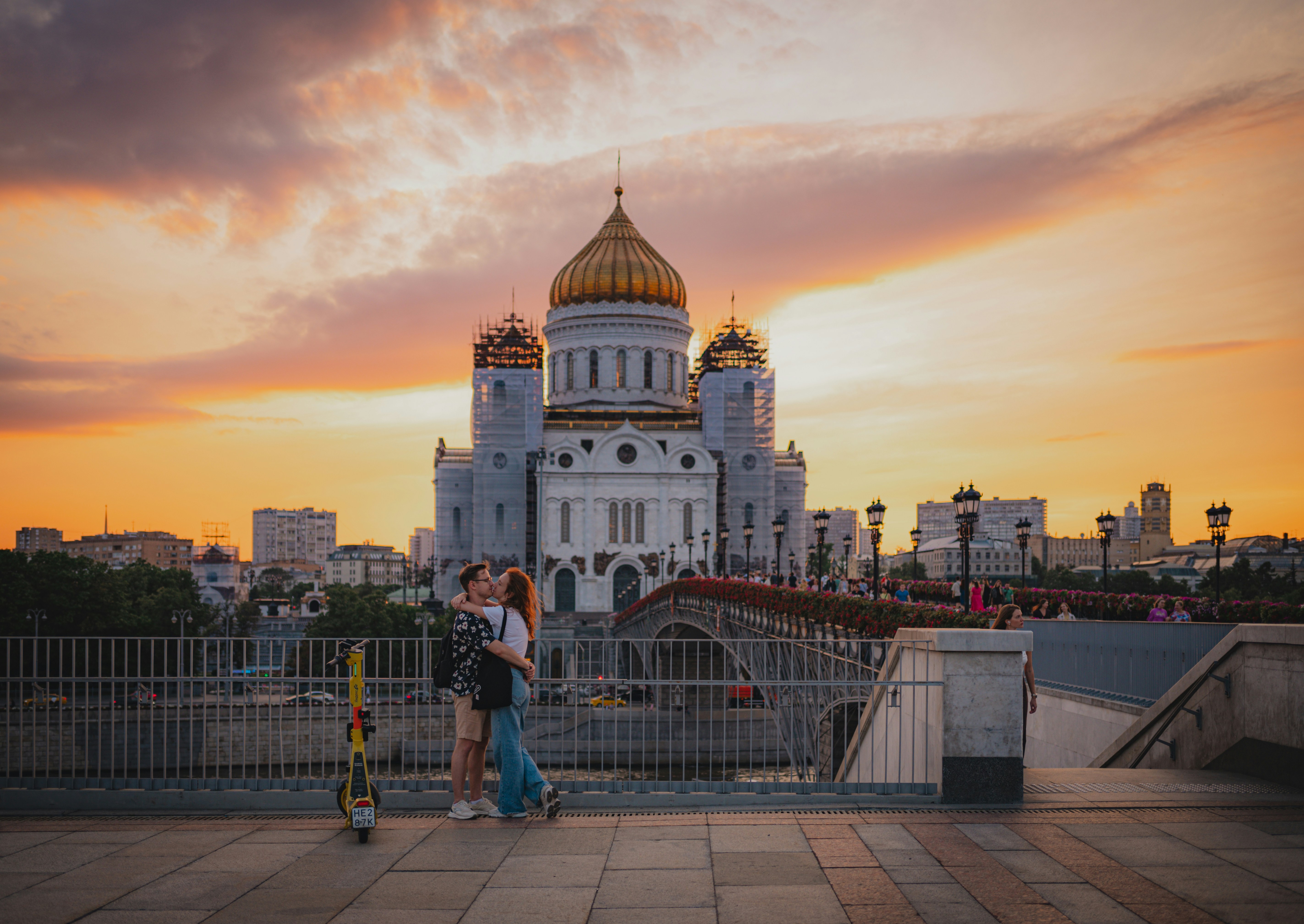 Couple kisses in front of a beautiful cathedral at sunset.