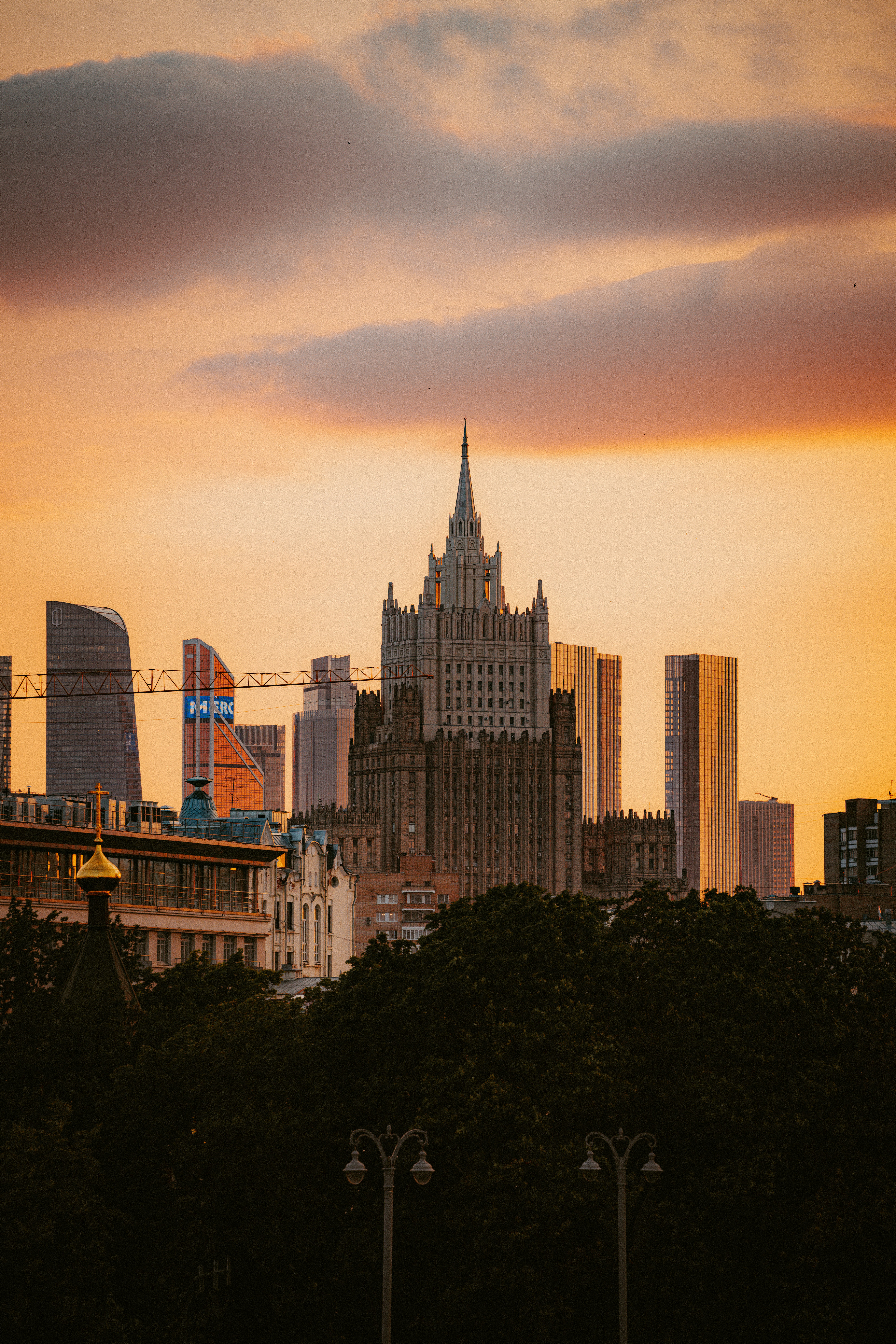 Moscow cityscape against a vibrant, orange sunset.
