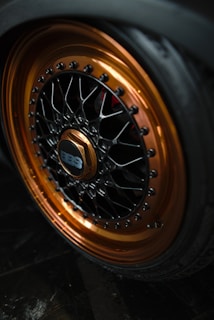 A car wheel with a copper and black rim.