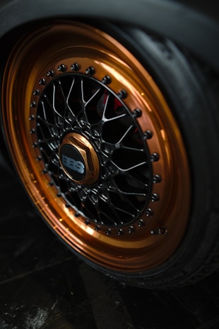 A car wheel with a copper and black rim.