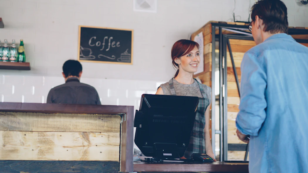 Barista serving a customer at a café counter