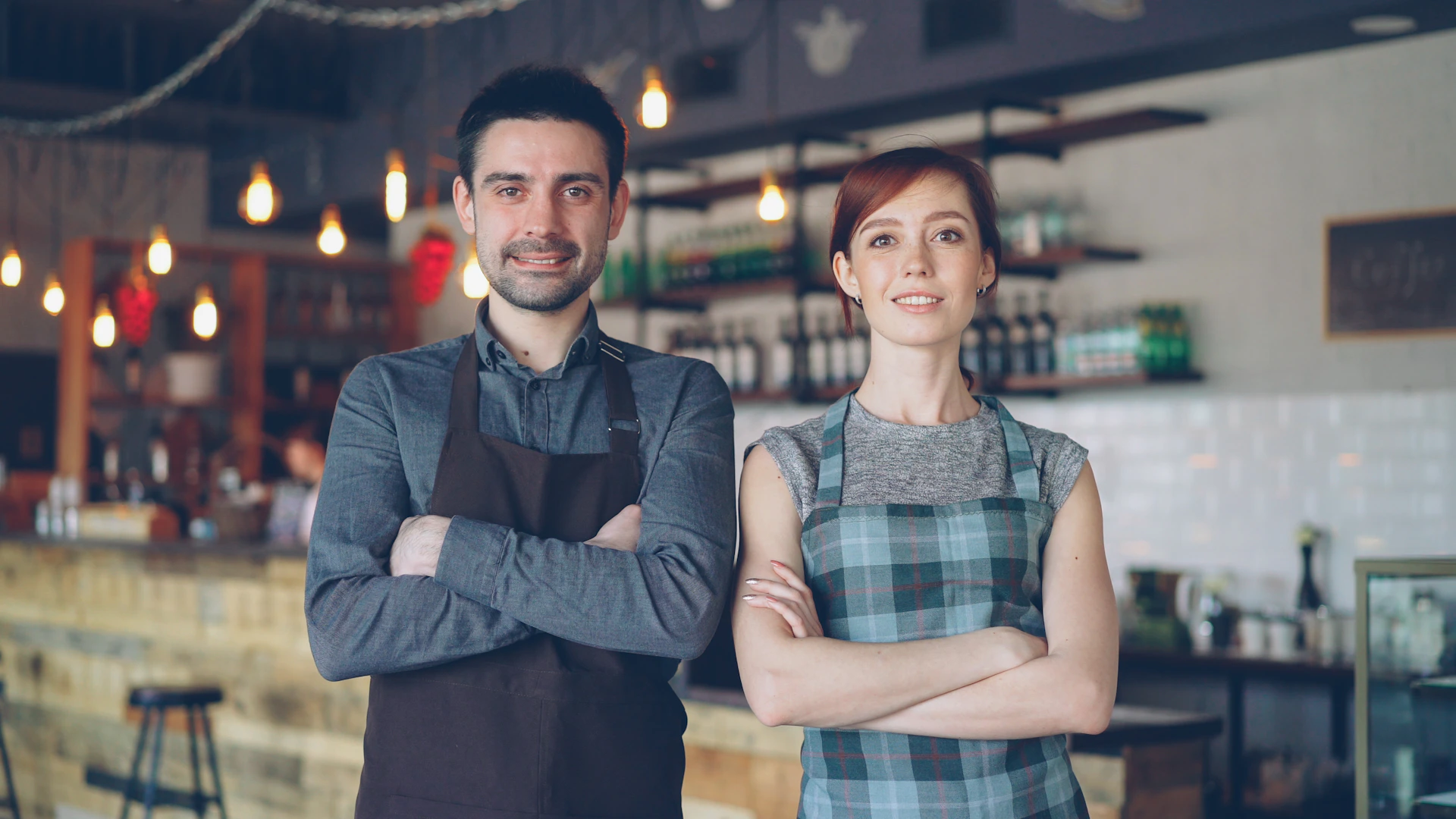 Two people pose confidently in a coffee shop.