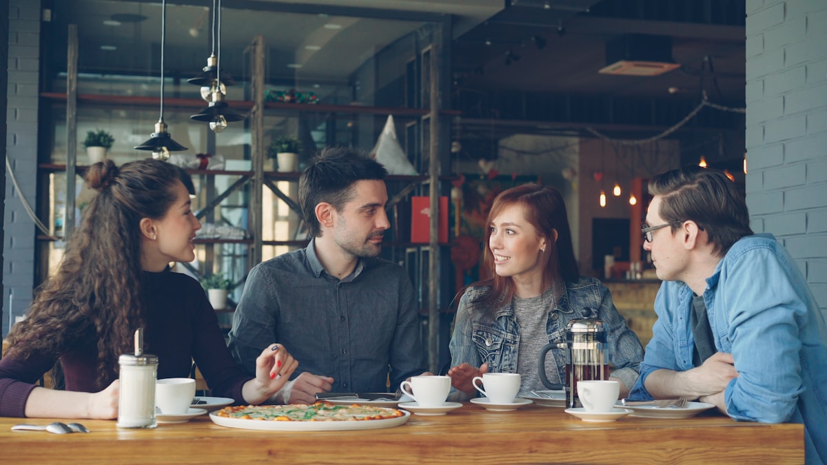 Freunde sitzen im Restaurant zusammen und unterhalten sich – rauchfrei genießen