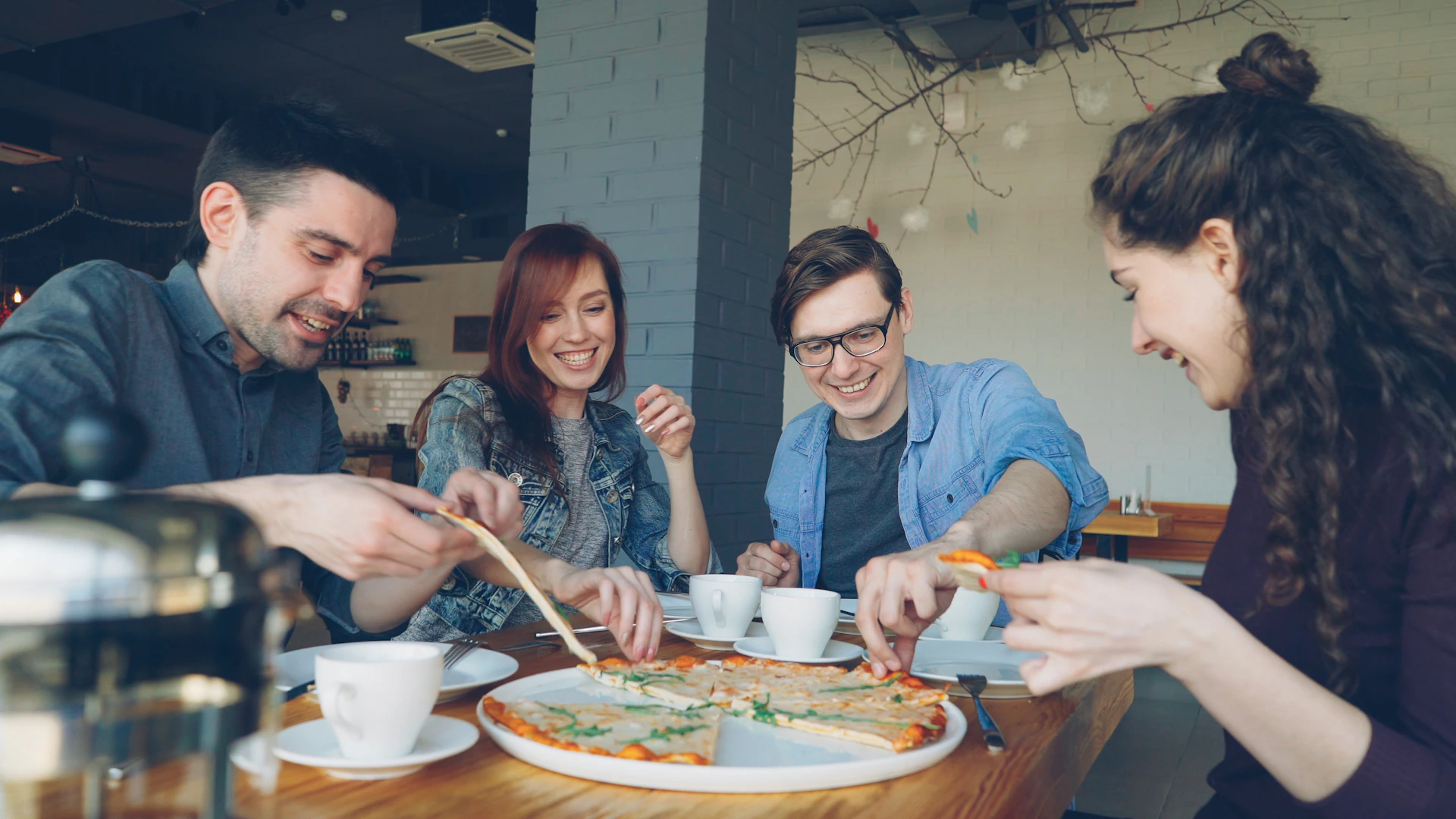 Friends are enjoying pizza together at a cafe
