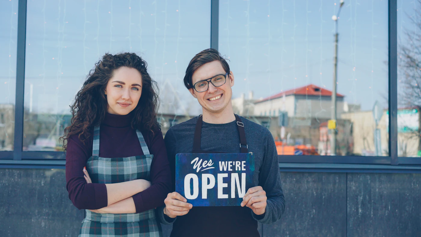 Two business partners standing outside their new shop