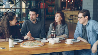 Friends enjoy pizza and conversation in a restaurant.