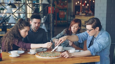 Friends share a pizza together at a restaurant.