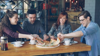 Friends are sharing a pizza at a restaurant.