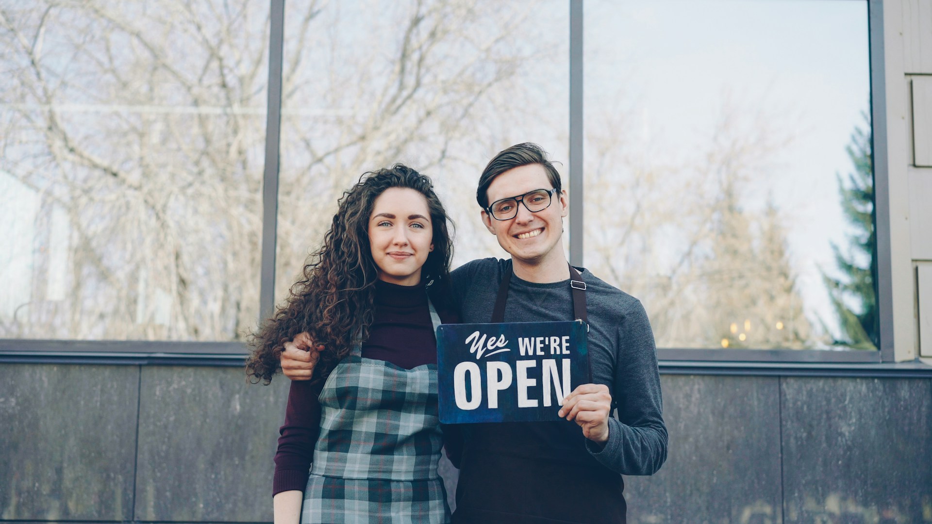 Two people are happy to announce that they're open.