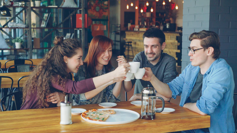 Friends celebrate with a coffee toast at a restaurant.